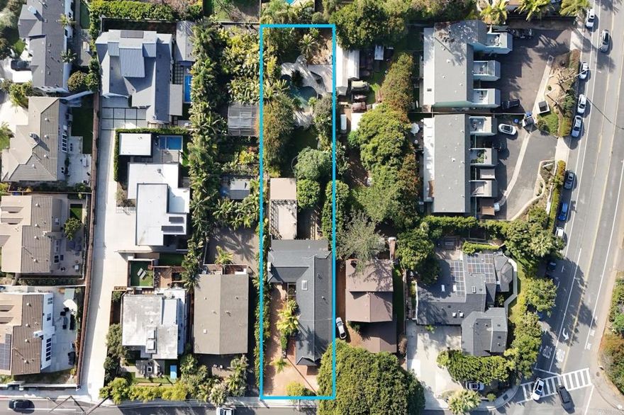 A rare opportunity to own a classic North County home lovingly lived in and cared for by the same family since 1965.  This coastal retreat is located west of the 5 and ideally situated on over a third of an acre.  Enter through the custom hand carved David Frisk front door and be transported to the South Pacific.  Abundant natural light, wood accents and stone combine to create a warm, calming, tropical atmosphere.  Thoughtful touches include authentic fossil stone flooring, wood sliding doors, river rock granite counter tops and exposed beams repurposed from the old Del Mar Pier.  The main level features a primary bedroom with direct access to full bathroom, a second bedroom that can also be used as an office or hobby room, a light and bright galley style kitchen with an extra-large west facing bay window and ample cabinet space, an adjacent dining area with additional storage and glass enclosed display options, a living room with built in shelves and fireplace.  There is also a two-car garage and plenty of driveway space for guests to park.    Downstairs, the lower level features a bonus / family room with built in entertainment system cabinets, washer & dryer with storage shelves, three bedrooms, two bathrooms with showers and abundant storage.  Direct access to the carport and backyard provides potential ADU conversion possibilities.  Enjoy outdoor living at it’s finest.  From the main level you will entertain guests or family on the covered patio and expansive deck.   From the lower level, immerse yourself in nature as you stroll through a private oasis.  The lush tropical landscaping features a variety of palms, plumeria and birds of paradise as well as mature fruit trees including banana, fig, loquat, mango and avocado.  Delight in the spectacular multi-level resort style saltwater pool featuring a slide, waterfall, grotto and jacuzzi.  The adjacent covered pool house features a BBQ, fridge and pool toy storage. Just a short distance away is Paul Ecke Elementary School and some of Leucadia’s finest restaurants, cafes, parks, coffee houses, shops and beaches.  North County San Diego is a special place and this quintessential North County coastal home is not to be missed.