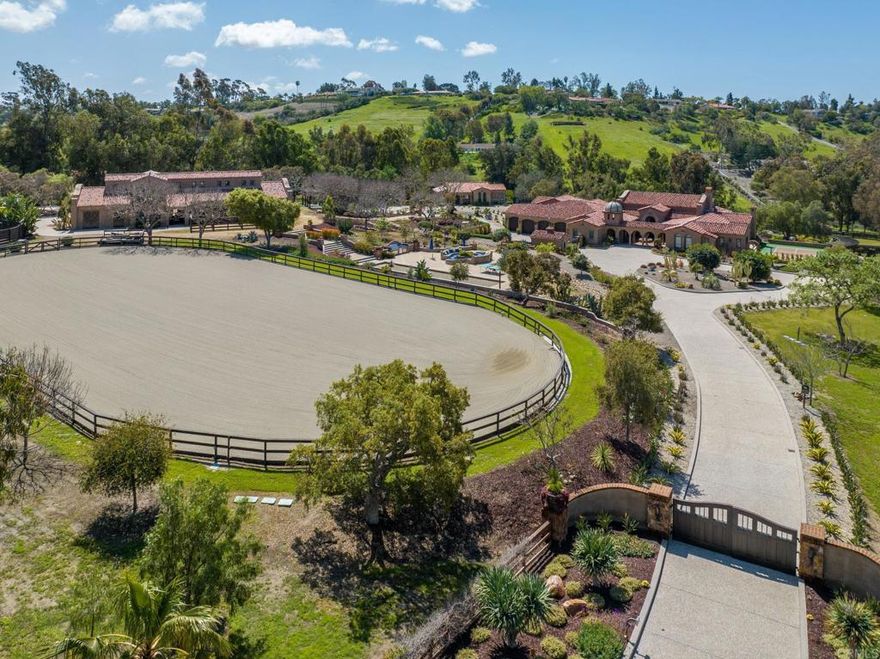 An unparalleled offering in the heart of Rancho Santa Fe’s coveted Covenant, this is one of Southern California’s premier equestrian properties and custom-designed estates, blending timeless European artistry with state-of-the-art amenities across 9.22 rare acres. Beyond the gates, lush landscaping leads to a world-class equestrian haven. The 8-stall barn spans approximately 4,654 sq ft, featuring custom ironwork, a gourmet kitchen, caretaker’s apartment, and 3-car garage. The property includes a riding arena, round pen, four-horse walker, and direct access to the Covenant trail system. A circular motor court with a bubbling fountain and antique Belgian church windows welcomes you to the 8,200 sq ft single-story main residence with four luxurious bedroom suites and a 4-car garage. The separate 1,183 sq ft guest house offers two suites, a full chef’s kitchen, living room, powder room, and 1-car garage. Every inch of the fresco design exudes authenticity and artistry — walnut hardwood flooring with intricate parquet and herringbone patterns, hand-carved woodwork, authentic hand-hewn beams, custom brick ceilings, and imported Turkish stonework. The kitchen, featuring a La Cornue range and top-tier appliances, flows into a great room with a retractable glass wall opening to a heated outdoor living/dining loggia. Resort-style amenities include a vanishing-edge Sukabumi lava-tiled pool with underwater speakers, spa, fire pit, and a full outdoor kitchen with a pizza oven. The primary suite offers his and her custom detailed dressing rooms and bath, while additional spaces include two offices, a professional gym, and a theater/game room with a full bar. The 9"-thick concrete wine vault even offers a viewing window into the pool. Outdoor recreation abounds with a bocce ball court, horseshoe pit, pickleball court, and multiple outdoor kitchens and fire pits. Thoughtful infrastructure includes central vacuum, natural gas, sewer, high-speed fiber, 800-amp electrical, commercial-grade irrigation, a well with water filtration, whole-house generator, and solar for the pool and home electricity. A legacy estate and lifestyle opportunity reserved for a select few, this property is not just a home — it’s a statement of achievement, passion, and vision. A true masterpiece designed to be cherished for generations to come. Experience life and luxury without compromise