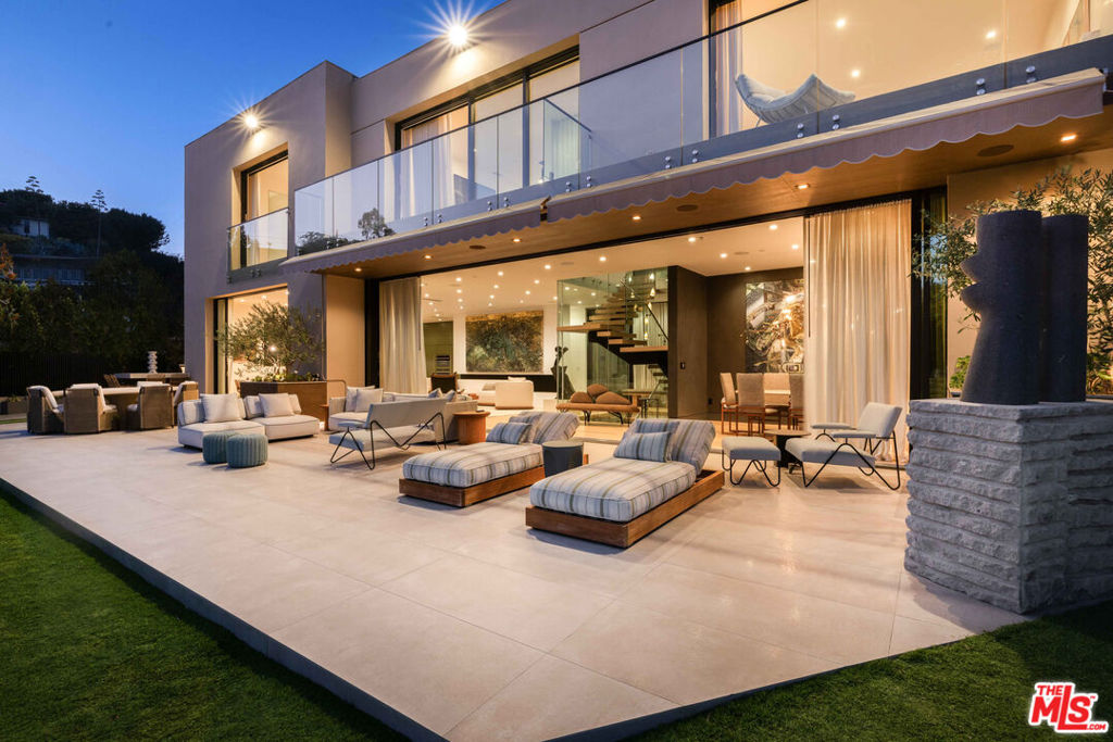 Set on one of Brentwood's most coveted streets, this three-story architectural masterpiece has been fully reimagined by Ashe Leandro, AD100 designer from New York, delivering a seamless blend of cutting-edge design and California indoor/outdoor living. The moment you enter the sweeping glass entryway, panoramic ocean views unfold, setting the tone for the home's striking aesthetic and unmatched sense of privacy.Boasting six bedrooms, the residence features a top-of-the-line chef's kitchen and expansive living spaces flooded with natural light through Fleetwood sliding glass doors that open directly to the backyard oasis. The upper level houses four en-suite bedrooms, including a lavish master suite with a grand walk-in closet and an oversized spa-like bathroom, complete with a stand-alone tub and steam shower overlooking the city and the Pacific Ocean.The lower level elevates entertainment to a new standard with a state-of-the-art home theater, fully illuminated onyx bar, temperature-controlled wine cellar, private gym, and guest bedroom, all seamlessly integrated with a Crestron home automation system for effortless living. Every corner of the home showcases meticulous design, exceptional craftsmanship, and a rare vision, making it perfect for families, couples, or any buyer looking to be in prime Brentwood with architectural integrity and panoramic views.