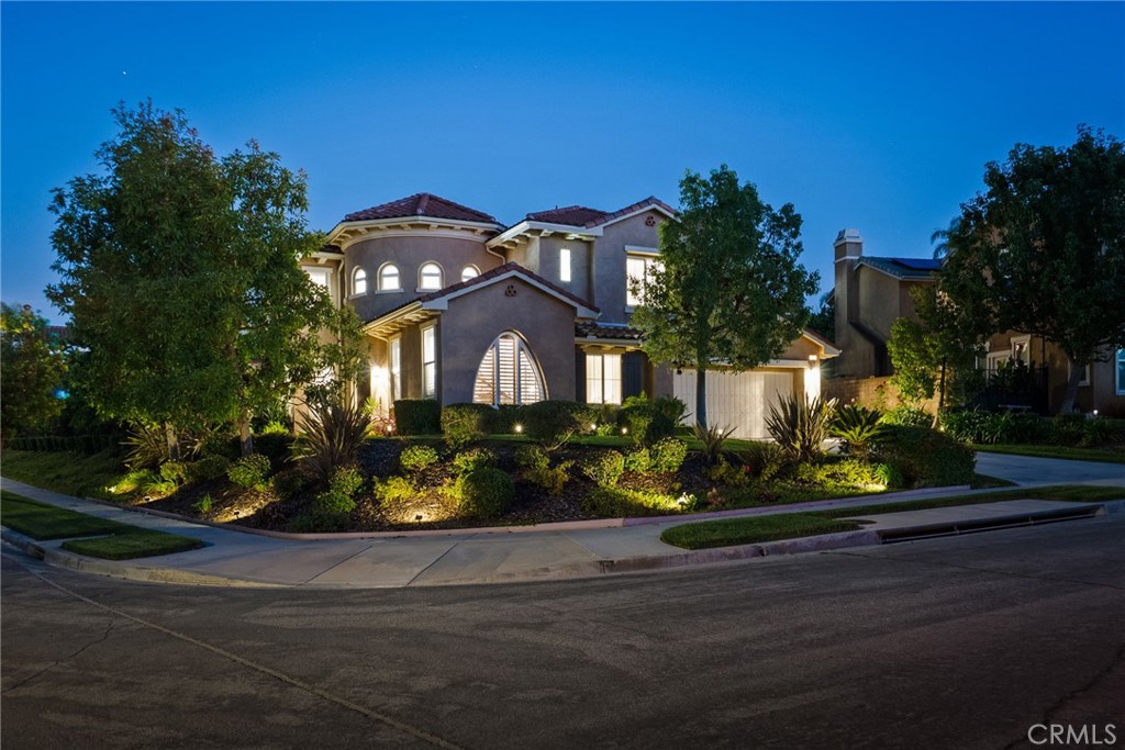 Welcome to this truly exceptional corner-lot residence in the desirable Brentwood community of Simi Valley, where elegance, comfort, and design come together seamlessly. The fully landscaped and beautifully illuminated lot features an array of vibrant plants and fruit trees, along with tiered backyard landscaping filled with lush, mature trees that create a private oasis surrounding the spectacular pool and spa with tranquil water features and custom lighting. Enter through a grand turret entryway with soaring ceilings and rounded walls that set the tone for the home’s distinctive Mediterranean/Spanish-inspired architecture. The formal living room showcases a unique picture window and a stunning curved staircase, while the formal dining room connects to a bar area and the expansive family room with dramatic high ceilings. The open-concept kitchen is a chef’s dream, complete with an oversized island with breakfast bar, Monogram six-burner gas stove, Sub-Zero refrigerator, warming drawer, convection oven, dishwasher, and under-cabinet lighting. The primary suite on the main level features dual closets and a luxurious soaking tub, accompanied by a guest suite with walk-in shower and a powder bath for visitors. Upstairs, a spacious loft anchors two large bedrooms with an extended Jack-and-Jill bath, plus another guest suite with its own full bath. Thoughtful upgrades include shutters throughout (including high-top windows and exterior doors), ADT security system, dual-zone HVAC, DC ceiling fans in all bedrooms, a three-car tandem garage with epoxy floors and 220V outlet for EV charging, and a large laundry room. With 5 bedrooms, 4.5 bathrooms, and every detail designed for beauty and functionality, this stunning home captures the essence of California living—luxurious, inviting, and unforgettable.
