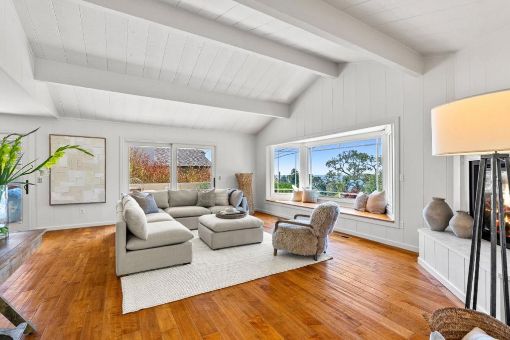 Nestled on a peaceful street just a few blocks from the heart of Carmel by the Sea, this delightful light-filled home is a perfect coastal retreat for hosting family and friends. With vaulted ceilings and warm wood floors, the living room, featuring a cozy bay window with ocean views, seamlessly flows into the kitchen, dining area, and out onto the expansive deck, ideal for memorable gatherings with sweeping ocean views. Relax in the bay window nook, enjoy the serene backyard with drought-tolerant landscaping, and unwind in your private oasis. Freshly painted and complete with a two-car garage, this home is just a short stroll to downtown and a local trail that leads straight to the beach.