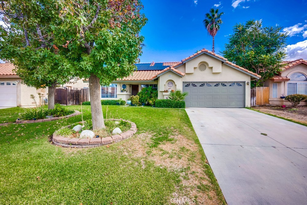 Welcome to this beautiful single story home, which has 3 bedrooms, 2 bathrooms and sits on a very large 10,454 square foot lot that offers space, flexibility, and future potential. The property features great curb appeal with a well-kept front lawn, light landscaping, and a terracotta-colored roof that adds warmth to its exterior. The driveway leads up to a two-car garage, with a walkway branching off toward the front entrance.
Inside, the kitchen overlooks the living and dining areas, creating a connected, functional space ideal for everyday living. The area features slanted ceilings, recessed lighting, and a ceiling fan, while sliding glass doors off the dining section provide direct access to the backyard and plenty of natural light.
A second living space, ideal as a formal sitting room or lounge, adds extra flexibility, while the hallway provides an open nook suitable for additional seating or decor. The home includes three bedrooms, including a spacious primary suite with direct access to the backyard.
The backyard itself is expansive, offering endless opportunities for outdoor entertaining, landscaping, or creating a private retreat. Leased solar panels provide an energy-efficient boost to the home. You'll want to make this your forever home.