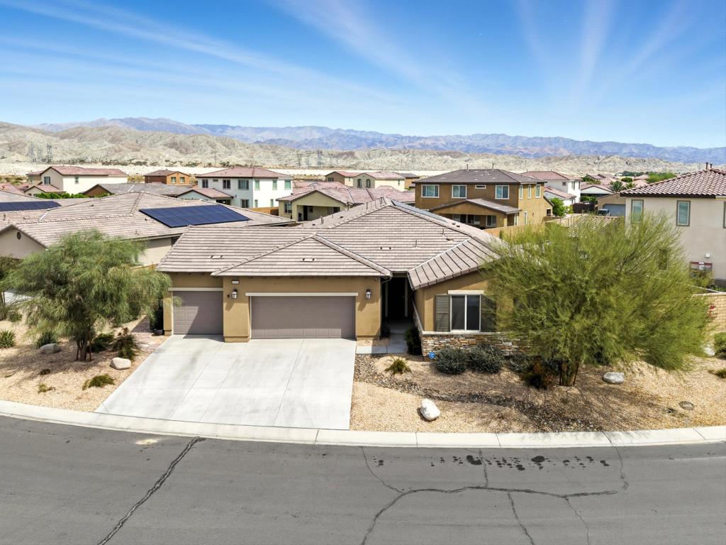 Stunning home in the highly desired gated community of Paradiso! This 4-bedroom, 3-bath showplace sits on an oversized corner lot of more than 10,000 sq ft and radiates model-home style from the moment you walk in ... GORGEOUS!Inside you're greeted with soaring ceilings, designer plank-style tile flooring (YES -- that is tile!) and a bright, open layout perfect for entertaining. The gourmet kitchen is a true centerpiece with an eye-catching backsplash, oversized quartz countertops, stainless steel appliances including double ovens, a large center island with seating, recessed lighting, and a walk-in pantry. A spacious formal dining room offers flexibility as a home office, media room, or play space.The split floor plan provides a private retreat for the primary suite with direct backyard access, a large walk-in closet, dual vanities, a soaking tub, and a separate walk-in shower. Three guest bedrooms are set apart on their own wing -- ideal for family and visitors -- and feature upgraded carpet, ceiling fans, custom window shades, and ample storage.Outside, the expansive yard wraps both sides and the rear of the home, creating an exceptional blank canvas for your dream pool, putting green, outdoor kitchen, or fire-pit lounge under the stars. Paid solar keeps energy costs low.But WAIT there's MORE! The oversized three-car garage is approximately 10 feet deeper than standard with high ceilings, LED lighting, and space for trucks, toys, or extra storage ... a garage lover's dream!Low HOA dues include cable and Wi-Fi. Close to top schools, shopping, I-10 access, and world-class golf and tennis, this property blends everyday comfort with vacation-style living... truly the perfect primary residence or desert getaway!