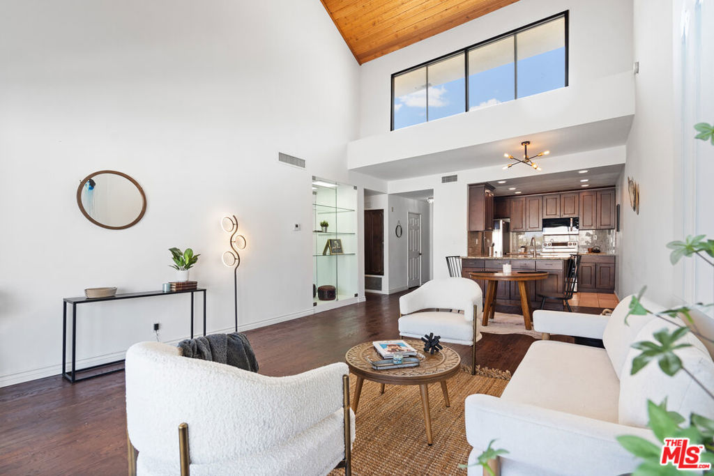 Experience elevated living in this stunning top-floor residence featuring dramatic vaulted ceilings and an expansive 1,450 sq. ft. open-concept design. With sweeping, unobstructed views of the Hollywood Sign, this 2-bedroom, 2-bath home blends sophistication with comfort at every turn. The spacious second bedroom offers a versatile loft space, ideal for a stylish home office, reading retreat, or creative studio. The serene primary suite is a true sanctuary, highlighted by a custom walk-in closet and an indulgent spa-like bath with dual vanities. Gourmet enthusiasts will love the fully updated kitchen complete with brand-new, premium appliances, while a newly installed HVAC system provides year-round comfort. Rich hardwood flooring flows seamlessly throughout the home, adding warmth and elegance. This exclusive community boasts resort-style amenities, including a sparkling pool and spa, a state-of-the-art fitness center, and two coveted rare two single parking spaces both conveniently located close to the elevator. With low HOA dues and a prime central location, this residence offers the perfect balance of luxury, convenience, and value.