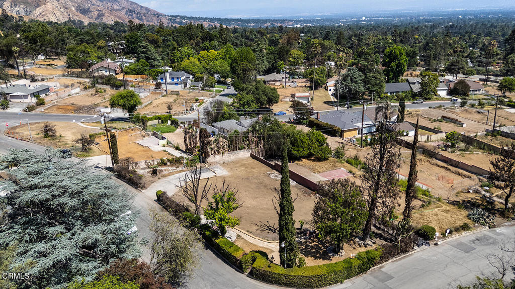 Located at the corner of Dolores Drive and Mount Curve Avenue, 1068 Dolores sits on a spacious corner lot bordered by mature hedges that create a private setting and a quiet buffer from the street. With frontage along Dolores, the site feels open, with mountain views from the front yard and a soft sense of separation from the surrounding neighborhood. Several neighboring homes remain standing, and the lot itself retains a striking mix of established plantings. Mature deodars and broad-canopied maples lend shade, scale, and a strong connection to the surrounding landscape. This part of Altadena is marked by wide skies, nearby trails, and a steady residential pace. 1068 Dolores offers a setting that balances privacy, openness, and proximity to everything that makes Altadena special. This was once the site of a 6 bedroom, 5 bath home with 3,834 square feet of living space on a 9,750 square-foot lot. With Phase 2 debris removal complete, the site is cleared and ready for its next chapter. The property is being sold as land only.