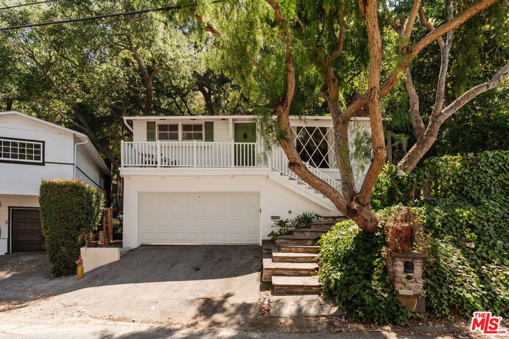 Tucked away in the serene canyons of the Beverly Hills Post Office, 9930 Westwanda Drive blends timeless charm with modern convenience. This warm and welcoming retreat features soaring ceilings, rich hardwood floors, and an effortless indoor-outdoor flow that embraces the beauty of canyon living. Thoughtfully designed for both relaxation and entertaining, the home offers multiple peaceful outdoor areas perfect for al fresco dining or gatherings under the stars. Inside, enjoy a cozy fireplace, stylish bar, and a spacious kitchen with an island that anchors the heart of the home. The generously sized garage offers exceptional flexibility ideal as a workshop, gym, art studio, or extra storage providing space to create, train, or organize to your heart's content. Just minutes from the city, yet worlds away in feel, this enchanting hideaway offers the ultimate canyon lifestyle with easy access to all that Beverly Hills has to offer.