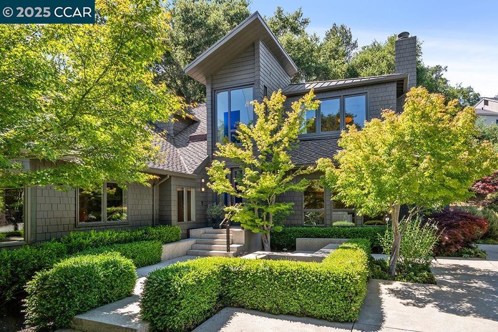 Nestled on one of Orinda's most coveted streets and in close proximity to the prestigious Orinda Country Club, this stunning 5-bedroom plus office, 3 full and 2 half-bathroom estate on 1.12± acres represents the epitome of California living. Originally designed by renowned architect William Wurster, though the original home had a much smaller footprint, some of the historic home still remains, adding character and architectural heritage to the property. Here, 5,086± square feet of thoughtfully crafted space showcases custom millwork, hardwood floors, and an architectural centerpiece—a floating staircase that sets the tone for the home. The main level flows from the entry through living and dining rooms to the heart of the home—a chef's kitchen with breakfast nook that opens to an expansive family room. Multiple French doors create seamless indoor/outdoor living, perfect for enjoying Orinda's year-round climate. The versatile bonus room and office space adapts to your needs, while two main-level bedrooms offer convenience for family and guests. The 3-car garage provides extra storage for your active lifestyle.