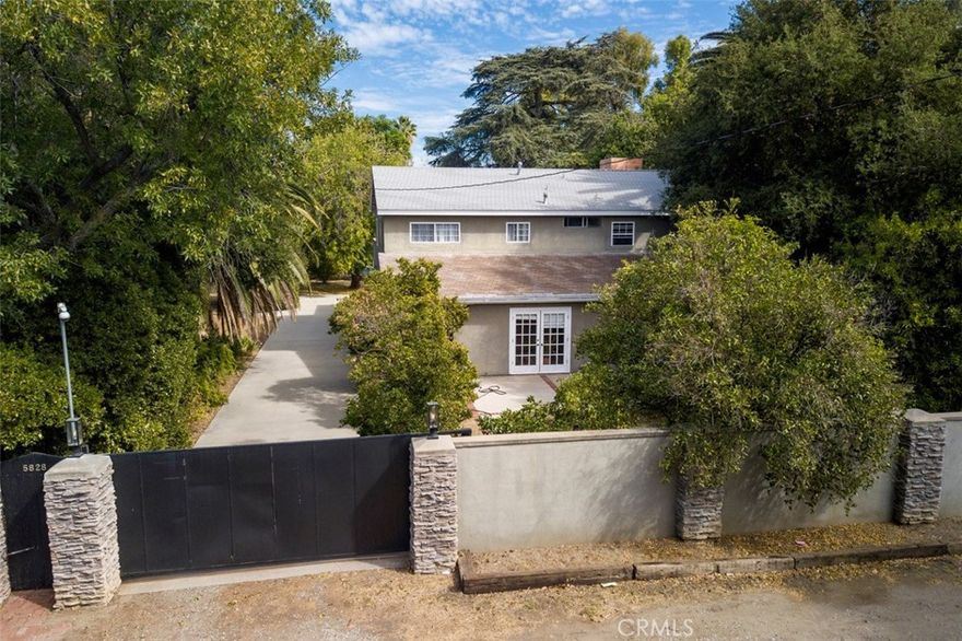 Endless Possibilities on Over Half an Acre in Tarzana. This gated, flat estate spans 21,765 sq. ft. and features a spacious 3,207 sq. ft. residence with 4 bedrooms and 3 full baths. The upstairs can be sealed off and create an ADU with 2 bedrooms/2 full baths, with large deck (20' X 18'), enclosed balcony with vaulted wood ceilings (18' X 16') and its own entrance and stairs from the yard. Perfect for multi-generational living or income potential. Outside is a large, gated Pool, Room for Grand Scale entertaining, room for another ADU or guest house. There is a massive 2,000 sq. ft. Metal Barn complete with loft, hoist system and space for 6 cars. Perfect for a collector's garage, art studio, sound studio or even an event venue. This flexible structure is a rare find. The property is zoned Agricultural offering even more freedom of use and possibilities. An adjoining parcel of an additional half an acre is also available for buyers seeking to expand the footprint. The adjoining property also has 2 address". An electric gate secures the property both for privacy and prestige. Truly a one-of-a-kind opportunity with unmatched versatility in the heart of desirable Tarzana! Perfect for Investors, Income Seekers, Artists, Collectors or those desiring a Private Estate with Pool and Expansive Grounds.