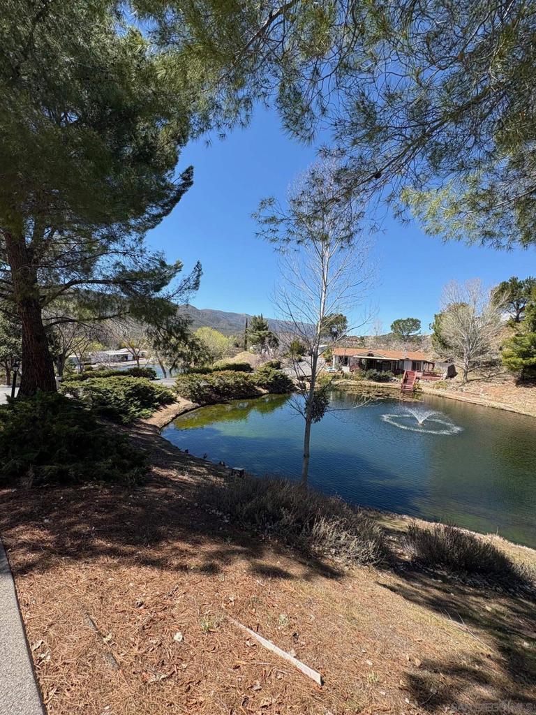 Wonderful Stone Ridge Estates home directly across from the lake. Water views from front porch, living and dining rooms. Built in 2011 on a permanent foundation with no land lease, this 2 bedroom/2 bathroom home is move-in ready! Sellers have taken exceptional care of this property. Features include newer carpet, newer window coverings, dedicated laundry room, central heat & air (extra large A/C unit installed 2024). All kitchen appliances convey. Concrete driveway has covered parking along with plenty of room for multiple cars. Ceiling fans, outdoor storage shed on cement blocking, pet enclosure with dog door for indoor/outdoor access and a small yard for gardening or enjoying the the surroundings. Newer Fire sprinklers on roof of home. 3 stocked lakes and free fishing. Peaceful 55+ community has a clubhouse w/ full kitchen, games, library, piano offering fun activities and get togethers! There's a Pool & jacuzzi as well as gym equipment for residents use. Perfect main home or secondary vacation spot. FHA & VA may be welcome!