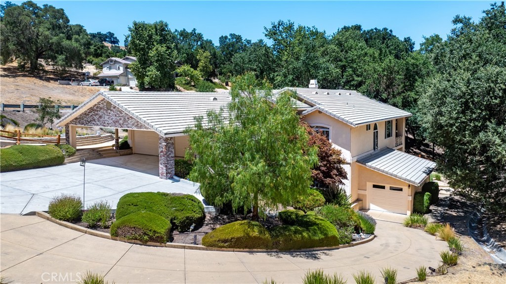 Lavish custom built Lake home nestled in wine country at Lake Nacimiento. Located in the most desirable gated community, Riverview Estates, set amongst multi-million dollar homes, majestic oak trees, mountains, meadows and small private vineyards. A master of design resembles a luxurious mountain retreat inside. Beautiful hand carved wood railings with jaw dropping high wood ceilings, open floor plan with wood and tile flooring throughout.. An abundance of windows with custom wood shutters flood the home with natural light while capturing wildlife on the move amongst your majestic oaks. Enormous deck off main level with stunning high wood ceiling is the perfect place to enjoy the tranquility of nature or host large get togethers. Main level also offers a sizable primary bedroom and bath with beautiful views, enormous walk in shower and closet with dressing area. Another guest room resides on main level with full bathroom. Downstairs offers library which doubles as a 4th bedroom with closet, family room and another guest room with full bath. Just off family room is a covered patio with hot tub and park like landscaping. 3 car garage on main level with secondary driveway to smaller garage. Meandering pathways around the home through majestic oaks with meadows mountains and privacy.Home is part of Heritage Ranch community with; pickleball courts, tennis courts, private boat launch/marina , campgrounds, equestrian center, library, recreation barn, hiking/biking trails and so much more. All age active community with many events. We have a fully staffed fire station. Just outside the gates are restaurants, gym, hair/nail salon, grocery store, gas station with self clean was for boats/RV/cars and K-8th grade school. All of this a golf cart away. Situated just 20 minutes from downtown Paso Robles and 40 minutes to beaches.