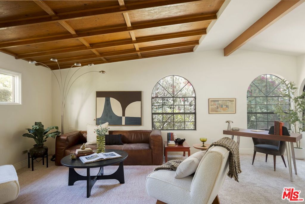 Welcome to 5011 El Verano. This 1915 cottage is tucked into an idyllic pocket of Eagle Rock. When inside you feel as if you've been transported to a remote place. Your retreat in the city. As you enter the home, you're welcomed with warm wood panel ceilings that pitch up for a dramatic living room. This expansive space can function as a living room as well as a flex space; good for an office, reading nook, or play area. In the center of the home is the dining room with a built-in corner bench with extra storage, a glass block wall with iridescent glass panel accents, and the most impressive stained glass window that brings color into the space as the light hits. The kitchen commands your attention with the stone wall, impressively pitched ceilings, a-frame window, vintage ceiling panels and a skylight. Behind the wood panel pocket door is the bathroom with antique mirrored storage cabinets and a sweet stained glass window. The primary bedroom is spacious and has a full closet wall. The second bedroom sits on the north side of the home with charming built in shelves and a full size closet. The sliding glass door leads to the courtyard. Enjoy your morning beverage here or take the stairs to the hilltop yard to enjoy the treetop and mountain views. The hillside is maximized for usability with a flat landing great for gatherings and an upper tier with more space for seating. You're minutes from Colorado and Eagle Rock Boulevard. Make Creatures Coffee & Plants your regular stop and conveniently enjoy amenities from Eagle Rock, and nearby Highland Park, and Glassell Park.
