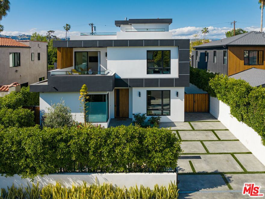 Welcome to this fully furnished, exquisitely done 2020-built Beverly Grove modern set behind gates and privacy hedges. Enter to discover wide-plank wood floors flowing throughout the open-concept floor plan. The living room includes picture windows and frosted privacy glass, adjacent to the formal dining room and partitioned by a floor-to-ceiling glass wine display. The family room is centered by a commanding stone fireplace and features Fleetwood doors that open to the outside, creating a seamless indoor-outdoor flow ideal for entertaining. The kitchen boasts custom cabinetry, a waterfall island with a cooktop, and top-of-the-line appliances. Downstairs includes a state-of-the-art theater with full-wall projection, surround sound, premium insulation, and amazing acoustics, as well as a game/entertainment room with a wet bar plus a guest bedroom. The primary suite offers a fireplace, private balcony with treetop and palm views, and a spa-like bath with elegant stonework, dual-sink vanity, extra-large shower with bench, soaking tub, and private toilet room. A junior primary has picture windows, a private terrace accessed by sliding glass, and an en-suite bath with a shower. Secondary bedrooms and bathrooms are spacious and light-filled. Upstairs also features convenient side-by-side laundry. The backyard includes a pool and spa with a water feature, an outdoor cabana, and a built-in fire pit. Enjoy a fantastic lifestyle in this prime Beverly Grove location near The Grove, Original Farmers Market, Melrose, Miracle Mile, Beverly Center, West Hollywood, Beverly Hills, and the very best of the Westside. Property will be available for showing on Nov 10th, 2025.