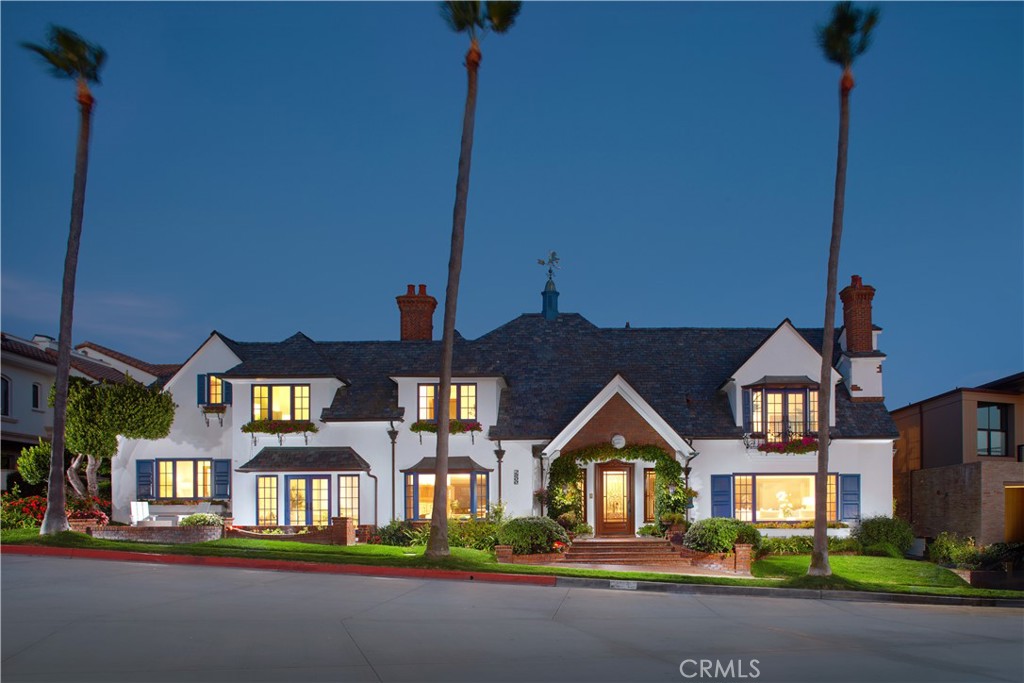 Boasting charm, a prime location, and stunning views, this coastal gem by renowned architect Brion Jeannette is available for the first time and offers an unparalleled living experience in the heart of Corona del Mar with 96' of west-facing frontage. Designed to capture uninterrupted vistas of the Pacific Ocean, Catalina Island, Peninsula, city lights, and Newport Harbor Jetty, this French Country-style cottage is situated on a unique 65' deep corner lot, spanning across two combined lots-- which cannot be duplicated today. Spanning approximately 4,770 square feet, the sun-filled interiors feature four bedrooms and three-and-a-half bathrooms. A charming living room, warmed by a wood-burning fireplace, seamlessly flows into a formal dining area. Adjacent, is a secondary living room where a garden window bathes the brick-surround fireplace in natural light. This inviting space opens to a delightful kitchen, complete with a sunny breakfast nook, an island, wood cabinetry, and new quartz countertops. The main level is rounded out by a powder room and an en suite bedroom offering a jacuzzi tub. Throughout the home, you'll discover character in every corner—antique leaded glass, beamed ceilings, wood flooring, new carpeting, and crown molding. Wood-framed doors open to a rare, beautifully landscaped backyard with multiple patios and a barbecue area, offering effortless grand-scale entertaining in a serene setting where ocean breezes and tranquility converge. Upstairs, three bedrooms await, including the sumptuous primary suite. This retreat offers an ocean and city lights view balcony, cozy fireplace, oversized marble walk-in shower, jacuzzi tub, marble vanity area with dual sinks, and a bonus room that could serve as an exercise space. Down the hallway, a private office with built-in shelving and another bonus room with an en suite full bath provide versatile spaces for work or leisure. Atop the home, the rooftop deck offers breathtaking views of the world-famous surfing spot, "The Wedge," where waves reach captivating heights. An oversized two-car garage with laundry completes the home. With panoramic views spanning the ocean horizon, Catalina Island, and Newport Harbor, this residence is perfectly positioned to appreciate Newport Beach and Corona del Mar's most iconic sights. All this, while being just moments from renowned beaches, Lido Marina Village, and John Wayne Airport.