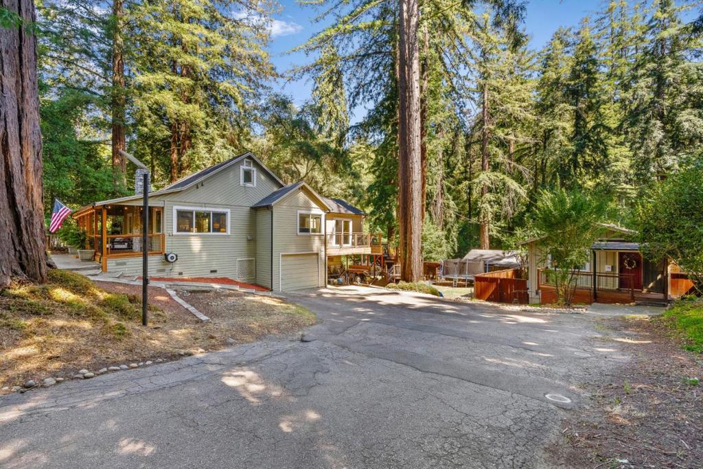 Welcome to your own redwood compound with two homes on one sun-drenched lot, fully fenced and designed for both everyday living and unforgettable moments. The main 3BR/2BA home lives like a 4-bedroom, with updated windows, hardwood floors, and a layout perfect for family life. Outside, kids can explore tree forts, zip lines, and an open lawn under the majestic redwoods. A legal 1BR/1BA cottage sits privately tucked away, offering excellent separation and rental income potential (last rented for $3,100/mo). Theres also a spacious garage, two separate workshops, ample parking, and a newly installed alkaline water system. Just seconds from town, minutes from local schools, and 30 minutes to Los Gatos & Santa Cruz coastline, this property offers comfort, flexibility, and the kind of outdoor lifestyle that's increasingly hard to find. Whether you're looking for multi-generational living, an investment opportunity, or just room to breathe, this redwood retreat delivers!
