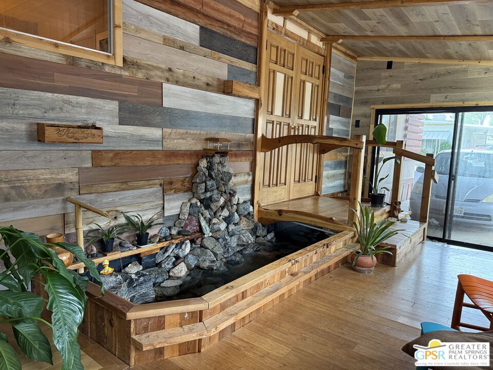 Don't miss your opportunity to own this unique, one of a kind home in Healing Waters Mobile Home & RV Park, a 55+ active community located in Desert Hot Springs. As you enter the covered indoor serenity garden, you will be awestruck by the waterfall and rock pond (ready for the fish of your choice if desired), and a Japanese inspired wooden bridge leads you to the dramatic entry doors. Artistic remodeling is highlighted throughout the home with the primary focus on repurposing, recycling and reusing. The kitchen counter tops, island, and walls boast reclaimed redwood and cedar from several parts of the state. The sink is recycled from England. Cork floors are cool in the summer and warm in the winter. There is an amazing oversized pantry, and access to the equally oversized attached workshop which also can be used for storage or a golf cart enclosure. Numerous creative touches abound in this 3 bed/2 bath double wide unit. The tranquil ambiance continues outside as you relax on the back deck and take in breathtaking mountain, desert and amazing sunset views. Park amenities include a large mineral spring pool, 3 mineral springs spas, wet and dry saunas, large clubhouse with banquet room, game room, library, and billards. There are also pickleball and shuffleboard courts. Hurry, you have to check this treasure out!