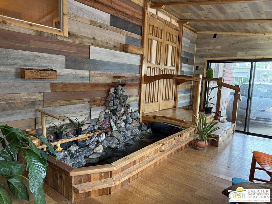 Don't miss your opportunity to own this unique, one of a kind home in Healing Waters Mobile Home & RV Park, a 55+ active community located in Desert Hot Springs. As you enter the covered indoor serenity garden, you will be awestruck by the waterfall and rock pond (ready for the fish of your choice if desired), and a Japanese inspired wooden bridge leads you to the dramatic entry doors. Artistic remodeling is highlighted throughout the home with the primary focus on repurposing, recycling and reusing. The kitchen counter tops, island, and walls boast reclaimed redwood and cedar from several parts of the state. The sink is recycled from England. Cork floors are cool in the summer and warm in the winter. There is an amazing oversized pantry, and access to the equally oversized attached workshop which also can be used for storage or a golf cart enclosure. Numerous creative touches abound in this 3 bed/2 bath double wide unit. The tranquil ambiance continues outside as you relax on the back deck and take in breathtaking mountain, desert and amazing sunset views. Park amenities include a large mineral spring pool, 3 mineral springs spas, wet and dry saunas, large clubhouse with banquet room, game room, library, and billards. There are also pickleball and shuffleboard courts. Hurry, you have to check this treasure out!