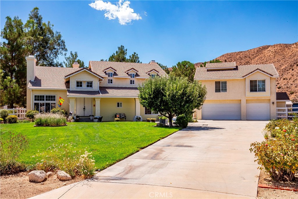 First time on the market! Welcome home to this gorgeous, upgraded, well cared for, custom two story home, with 5 bedrooms, 3.5 bathrooms (main living quarters), a separate upstairs garage apartment/open loft concept with another full bathroom, on beautifully landscaped acreage, with flat equestrian property, RV access for all your toys, a 3 plus car garage, completely fenced in the back, on a cul de sac, nestled against the rolling hills in the sought after Sterling Ridge tract in Acton-is an absolute must see! Walking up the long driveway, you soak in the true beauty of this property. Stepping into the home from the outside, you are greeted by wooden double doors, and a large, tiled entry way that flows seamlessly down the steps to the first floor. You are welcomed by natural light, tall, vaulted ceilings, spacious rooms, new carpet and new luxury vinyl plank flooring in all of the bathrooms. The grand foyer flows into the open living room, with a fireplace that leads into the formal dining room, all great for entertaining. Moving into the heart of the home, is the showstopping kitchen with custom granite countertops, center island, warmly stained soft closing cabinetry with new hardware, wood planked tile flooring, upgraded stainless steel appliances that open up to an informal dining area, and a spacious family room with another brick fireplace for those cool desert days and nights. Downstairs also has a master/primary bedroom (or a home office space) with an attached full bathroom, there is also a half powder bathroom and ample sized laundry room, cabinets for more storage, a utility sink, and built-in laundry chute from the upstairs. Transitioning to the upstairs is the lovely staircase with wooden railing that takes you to the landing of the second story. The sprawling master bedroom greets you at the top of the stairs with double doors, vaulted ceilings, and fireplace. There are two walk in closets as you lead to the master bathroom ensuite with dual sinks, new sink faucets, walk in shower and large soaker tub. Down the hallway, there are 3 more good sized bedrooms and a full hall bathroom. Enjoy spring and summer days in this backyard paradise! Stepping outside onto the back patio, into the stunning oasis in the desert, be entranced by the sweeping views, lush green grass that seems endless, mature trees, plants, flowers in bloom as far as the eye can see.