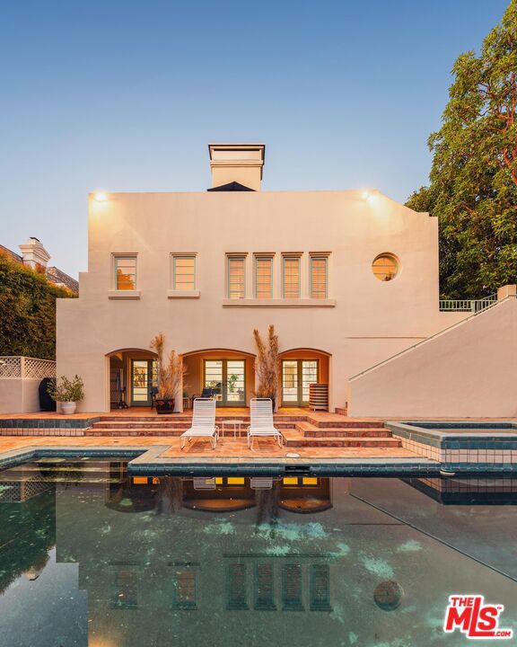 Located in the prestigious guard-gated community of Bel-Air Crest, this elegant custom Mediterranean sits on a quiet cul-de-sac and offers a rare combination of privacy, scale, and comfort. A circular driveway and gated three-car garage with direct access set the tone for this grand residence. Designed for entertaining, the home features multiple patios and terraces, a large pool and spa, and a flat grassy yard surrounded by mature landscaping, an ideal setting for both intimate gatherings and grand occasions. A formal entry with a sweeping staircase and two-story ceilings leads to an expansive living room with a fireplace and multiple sets of French doors framed by graceful arches. The oversized formal dining room comfortably seats twelve and includes a wine cellar and butler's pantry, with views to the outdoor patio. The chef's kitchen features a center island and walk-in pantry and connects seamlessly to the family and breakfast rooms, both with fireplaces. A handsome study with custom built-ins, an oversized powder room, and a separate maid's room complete the main level. Upstairs, four generous bedroom suites include the luxurious primary suite, complete with dual bathrooms joined by a connecting shower, two walk-in closets, a wet bar, private sitting area, fireplace, and a wall-to-wall balcony with sweeping canyon and treetop views. The lower level offers a secondary family room, gym or office space, and direct access to the backyard. Bel-Air Crest residents enjoy exclusive amenities including a community pool and spa, fitness center, tennis courts, playground, clubhouse, and 24/7 security. Just minutes from all that Los Angeles has to offer, this private and thoughtfully designed home is a true escape in the heart of the city.