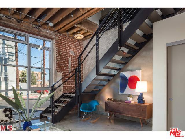 This is a townhome style end unit w/private patio and lots of light from two walls of windows, vaulted ceilings and lots of exposed brick. Upper floor has 2 bedrooms, large master w/balcony and full bath, downstairs is kitchen/living area and guest half bath. Washer dryer hookups in unit. Garage parking space included, option to lease storage in building. This was the showcase unit for the final phase of Barker!! Come enjoy all that the bustling Arts District has to offer.