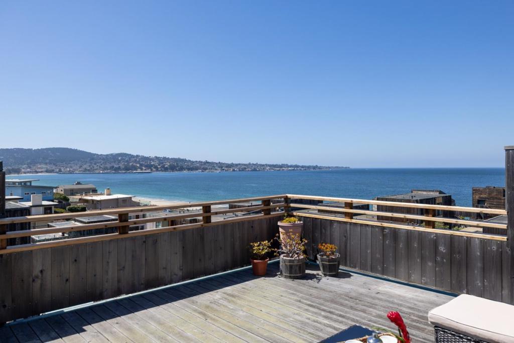 The rooftop deck is a true showstopper offering unobstructed, 180-degree views of the Pacific Ocean and the iconic Monterey coastline. Watch sailboats drift across the bay, spot whales playing in the surf, and soak in the golden hues of sunset as they melt into the horizon. Step inside this beautifully maintained 2-bedroom, 2-bathroom condo perched above the sparkling shores of Monterey Bay and discover an open-concept layout that maximizes natural light and ocean breezes. The spacious living area flows seamlessly into a modern kitchen, ideal for entertaining or quiet evenings at home. Each bedroom is a serene escape, with ample closet space and ensuite bathrooms. You will enjoy the private balcony for morning coffee or sunset cocktails. With 1,214 square feet of thoughtfully designed living space, this coastal retreat offers the perfect blend of comfort, style, and convenience.