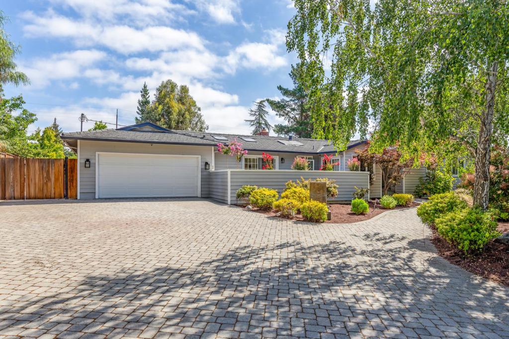 Just moments from town, this thoughtfully designed home is flooded with natural light via skylights in every room, features incredible lofty ceilings, and has lovely outdoor spaces surrounding the home. A verdant natural garden precedes the covered entrance, and once inside you are met with gleaming hardwood floors that carry throughout each spacious room. The kitchen features stunning granite countertops, a cozy breakfast nook, and doors to a large front patio perfect for dining alfresco or sipping morning coffee. The fireside living/dining room sits beneath vaulted ceilings, and the family room is open to the kitchen, ideal for entertaining, with doors to both the front and back patio and yard. The bedrooms are collected on one side of the home for privacy. There you'll find a bedroom suite, the primary suite with a completely private patio and an attached office, and an additional bedroom with high ceilings. Outside, your elevated deck looks out over a vast stretch of lush lawn surrounded by manicured plantings and mature trees. A home that exemplifies indoor/outdoor living, with bright & airy living spaces primed for gathering with friends & family. Located on 17,182 sq ft in a desirable pocket of Los Altos just moments from Rancho Shopping Center, downtown, & commute routes.