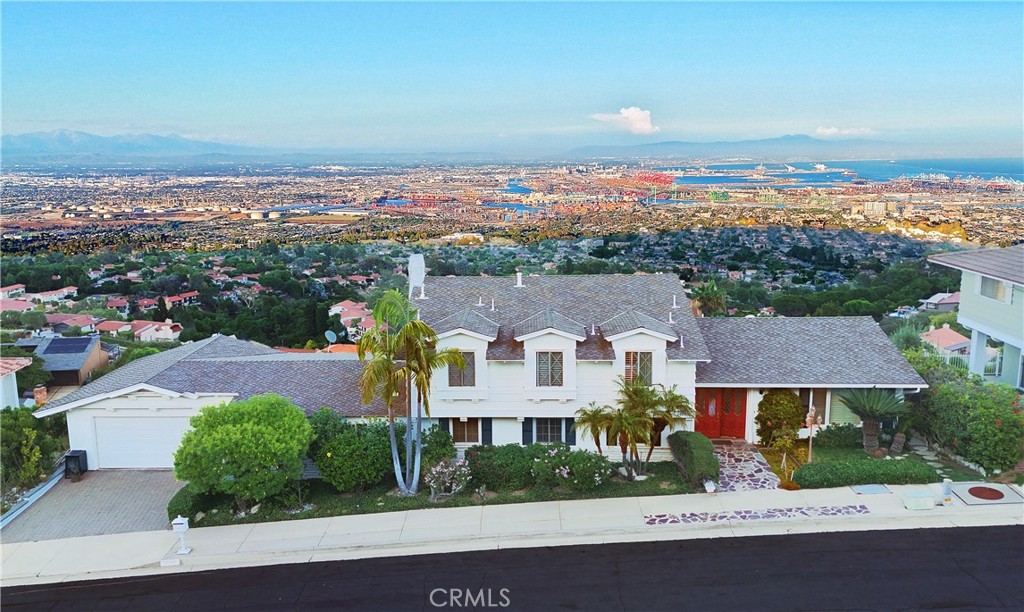 Welcome to the pinnacle of Miraleste Hills living! Perched high above the coastline, this custom-built residence has been designed to fulfill every desire. From its commanding position, the home captures a sweeping panorama—stretching from the iconic Hollywood Hills & the glowing skyline of Downtown LA, to the picturesque coastal reaches of Dana Point & San Clemente. Wake up to radiant sunrises over the harbor, mountains, & wind down w/sunsets that ignite the city skyline in dazzling color. Inside, you’ll discover 3 bedrooms & 3 baths across 2,280 sq. ft. (per assessor), with an additional ~630 sq. ft. of enclosed flex space connecting the family room & garage. The floor plan was thoughtfully designed to showcase the extraordinary views from nearly every room. The grand entryway introduces a guest half bath & opens to light-filled living spaces. Upstairs, the primary suite offers a walk-in closet, private bath w/shower & a balcony where dusk gives way to a million twinkling lights. The second bedroom shares the same captivating vistas, while the spacious third bedroom & hallway bath complete the upstairs level. The elegant living room w/walls of glass, invites natural sunlight & frames the breathtaking scenery. The adjacent dining room ensures every guest enjoys a memorable view—no matter where they sit. The kitchen is designed for culinary adventures complete with Travertine floors, solid walnut cabinets, custom granite countertops featuring a 5 burner induction stove overlooking the stunning view. The two separate cooking areas offer ample room for more than one chef on those special occasions. One area includes a gas oven w/ microwave/convection oven & the other area offers an electric oven & a Miele two burner gas cooktop w/griddle. Other features include a walk in pantry, dishwasher, garbage disposal, a wine/beverage cooler and versatile center island. The semi-open concept opens out to the comfortable family room with limestone fireplace all focused on the breathtaking 180°+ view. An expanded living area of approximately 630 sq. ft. offers endless possibilities—currently used as a library, music room, and gym—anchored by a Steinway piano and surrounded by lush greenery. Walls of glass and a sliding door leading to a spacious deck with a jacuzzi/hot tub, perfect for relaxing under the stars. You are drawn outdoors to the balcony whether you are soaking in the jacuzzi or pointing out to all of the landmarks along the coast and in between.