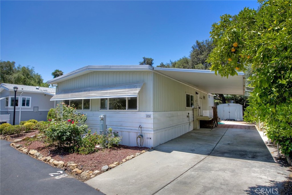 Nestled in the heart of the serene and picturesque Oak Crest Estates, this charming 3-bedroom, 2-bathroom manufactured home offers a perfect blend of tranquility, modern comfort, and community living. Spanning approximately 1,200 sq. ft., this inviting residence is situated in a 55+ co-op, land-owned community, providing an affordable and vibrant lifestyle surrounded by Fallbrook’s breathtaking natural beauty. Step into a light-filled, open-concept living space designed for comfort and relaxation. The spacious living room flows seamlessly into a formal dining area, ideal for entertaining guests or enjoying quiet evenings at home. The well-appointed kitchen boasts ample cabinetry and a functional layout perfect for preparing meals with ease. The primary suite features an en-suite bathroom for added privacy and convenience. The second bathroom is tastefully updated, offering a tub/shower combo. Additional highlights include newer flooring, double-pane windows, central heating and air conditioning, and a washer/dryer for in-home laundry. Outside, a covered carport accommodates two vehicles, and a storage shed provides extra space for gardening tools or seasonal items. The low-maintenance lot is adorned with native landscaping, complementing the community’s commitment to preserving the natural surroundings.
Community Features Oak Crest Estates is a hidden gem, offering an unparalleled living experience for those seeking a peaceful yet engaging retirement. Spanning over 8.5 acres of lush, oak-lined land, this 55+ co-op community fosters a strong sense of camaraderie and pride among residents. The low HOA fees ($494/month) cover essential utilities, including water, sewer, and trash, making homeownership both affordable and hassle-free. Residents enjoy access to a wealth of amenities, including: Clubhouse: A hub for social activities, featuring a recreation room, billiards/card room, and a cozy library for quiet relaxation. Heated Pool & Spa: Perfect for unwinding or staying active, the pool and spa are maintained to resort-like standards. Walking & Hiking Trails: Scenic trails wind through the community, offering stunning views of majestic oak trees, seasonal streams, and dramatic rock formations. Community Garden: A space for green thumbs to cultivate their own produce or flowers, fostering a connection to nature. RV Parking & Car Wash Facility: Convenient amenities for road-trippers and vehicle maintenance.