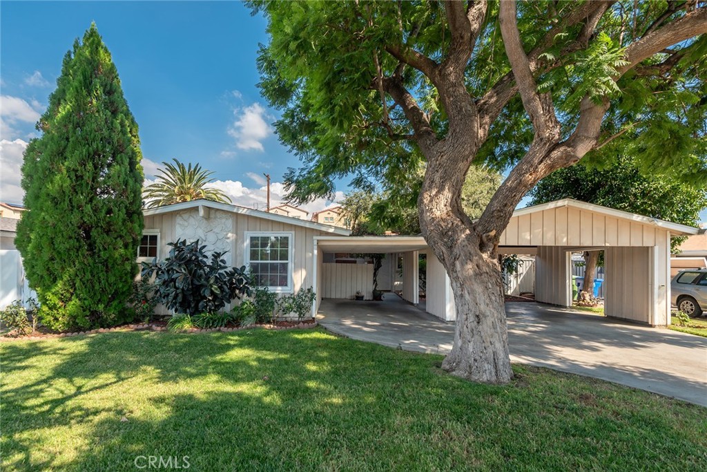 Welcome to this remarkable 4-bedroom home nestled in the desirable Mission Hills neighborhood, featuring a well-designed junior ADU that is seamlessly connected to the main living space. This versatile suite includes its own private full bathroom and a cozy sitting area, along with a convenient kitchenette and a sliding door that opens to a serene private patio. The main home offers three additional bedrooms and two full bathrooms, ensuring ample accommodation for family and guests. The interiors are adorned with vaulted bright white ceilings and newer wood flooring throughout, creating a spacious and inviting atmosphere. A formal living room welcomes you with its charming fireplace, perfect for warm gatherings. One of the bedrooms has been thoughtfully opened up to serve as a den or family room, but it can easily be converted back to a fifth bedroom, in accordance with assessor's records. An elegant formal dining area complements the bright white kitchen, which features a delightful breakfast nook for both casual and formal dining experiences. The home also includes an indoor laundry room for added convenience. Outside, you’ll find three covered carport spaces and a beautifully landscaped backyard—a true gardener’s dream—complete with a covered patio ideal for outdoor relaxation and entertaining.