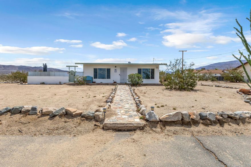 Step into this beautifully remodeled two bedroom, one bath mid-century modern home located just minutes from the entrance of Joshua Tree National Park in 29 Palms. Designed with charm and comfort in mind, it features vaulted wood beam ceilings, a stylish kitchen, and oversized windows that fill the space with natural light and capture panoramic desert views. The corner lot offers an inviting enclosed patio complete with a hot tub, barbecue, and seating area, perfect for stargazing or entertaining under the desert sky. Situated in a great neighborhood close to hiking trails, downtown restaurants, and the nearby Marine Base, this home combines convenience with the ultimate desert lifestyle. Whether you're looking for a full-time residence or a vacation rental, this turnkey property is truly one of a kind and ready for its next owner to enjoy. Schedule your showing today!