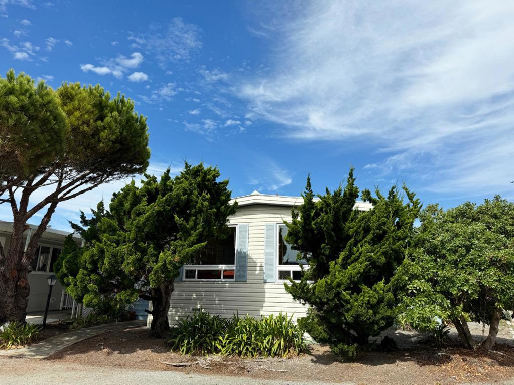 Another incredible price reduction for the same great unit! Situated on a corner lot on an interior street in Canada Cove; this spacious unit, 22 Sea Breeze Drive. A two-car carport offering side-by-side parking plus a ramp into the side entrance, makes easy parking and getting into the house under the cover! Large and open floor plan with big picture windows facing south in the living room streams in the light. Entertaining is encouraged with the large dining area with built in cabinetry. Two bedrooms and two bathrooms, plus a sun porch makes this unit an easy hit! Laundry room with storage. This 55+ park offers community, exercise room, seasonal saline pool, billiards and bingo and an outdoor bocce ball court. Living is easier here.