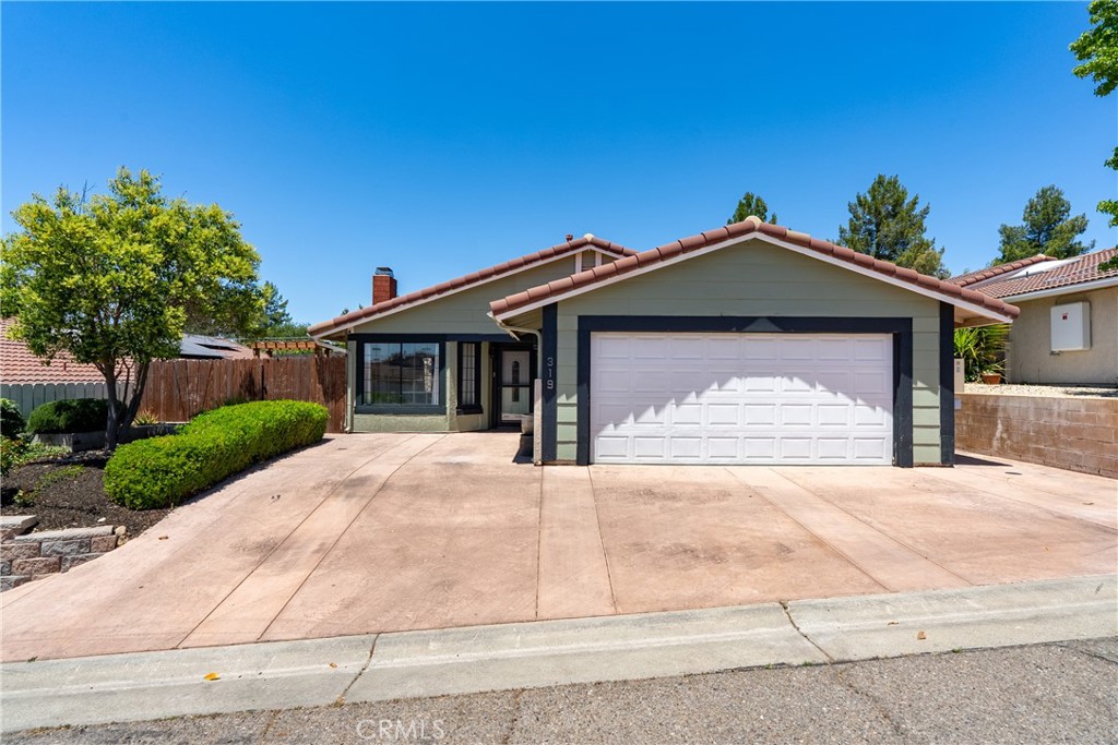 Welcome home to 319 Primrose Lane in picturesque Paso Robles, a stylish and modern residence offering comfort, convenience, and impressive upgrades. This beautiful 3-bedroom, 2-bathroom home features 1,378+/- sqft of thoughtfully designed living space. Step inside and experience an inviting open floor plan seamlessly connecting the living room, dining area, and kitchen. Enjoy indoor-outdoor living with convenient backyard access directly from the living room. The main living spaces and bedrooms feature elegant tile flooring, while integrated Alexa capabilities provide smart-home control of interior lighting. The kitchen is a culinary delight with stainless steel appliances and featuring a charming coffee bar, hutch, and dedicated seasoning cabinet. The primary suite offers luxurious touches, including attractive hard wood doors! Both the primary bathroom and guest bathroom boasts contemporary amenities such as heated and illuminated mirrors, tiled shower, and an updated vanity. Outdoor living is exceptional, with a spacious concrete porch complemented by a pergola for shade, an outdoor sink, and refreshed landscaping highlighted by dark brown gorilla bark. The tiered backyard includes two distinct sitting areas, perfect for soaking in the breathtaking west side views. Further enhancing the home’s appeal are outdoor security cameras, a leased solar system equipped with battery backup and an electric car charger, and two additional private parking spaces created by poured concrete in the front. A two-car attached garage adds to the convenience and functionality of this remarkable property. Don’t miss the opportunity to own this beautifully appointed home!