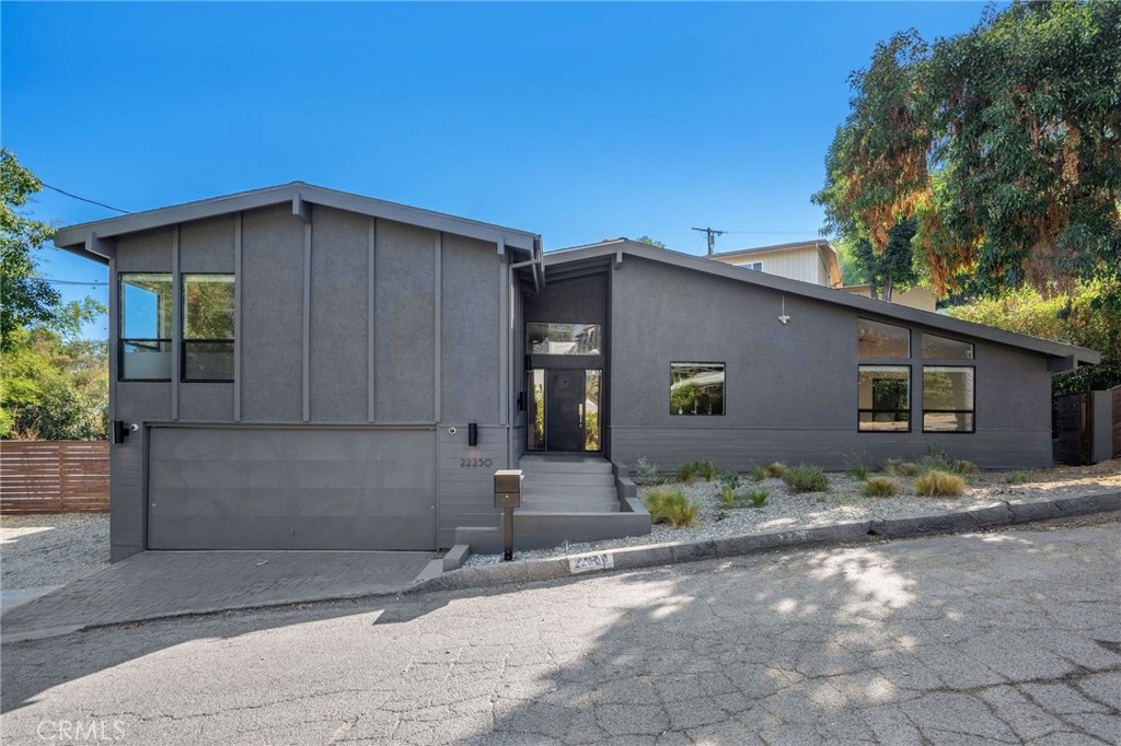 Located South of the boulevard on a quiet street in one of Woodland Hills’ most desirable pockets, this fully upgraded Mid-Century Modern home offers 4 bedrooms, 2.5 bathrooms, and approximately 1,970 square feet of thoughtfully designed living space. The property is framed by a neat, well-maintained landscape that complements its character-rich design.
Inside, the home highlights its clean architectural lines, expansive windows, refined wood flooring, and a seamless flow between indoor and outdoor spaces. The modern kitchen showcases premium cabinetry, LED backlighting, stone countertops, stainless steel appliances, and a generously sized island overlooking the living room and dining space. The main living space features a fireplace, high ceilings, and large windows letting in abundant natural light. Glass doors from the living room lead to the outdoor space with a covered patio and a maintained private grassy yard. Interior highlights include a large primary suite with a renovated bathroom and designer finishes, complemented by additional baths featuring geometric motif tile and a convenient powder room.
Nature-lovers will appreciate being approximately 20 minutes from Topanga State Park and Malibu beaches. Located just minutes from award-winning and highly coveted private and public schools (less than 1 block from WHECES Elementary School). Close to a variety of shops and restaurants, including The Village at Westfield Topanga, and Topanga Mall, Ventura Blvd and the highly anticipated new Rams facility.