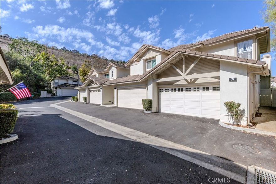 Welcome to 5931 E Rocking Horse Way #31—where peaceful mornings, elevated living, and timeless design come together in one of Orange’s most coveted gated and 24 hours guarded communities. Step inside this beautifully maintained end-unit townhome and feel the warmth of natural light dancing across rich wood floors. The open layout, dramatic ceilings, and cozy fireplace create a space that’s both inviting and refined. Whether you're hosting dinner in the dining room or unwinding in the spacious living area, every corner feels like home. The chef’s kitchen is a dream come true: gleaming granite countertops, stainless steel appliances, and abundant cabinetry make it as functional as it is stylish. With three bedrooms and two and 3/4 baths—including a downstairs suite with 3/4 bathroom perfect for guests or a home office—this home offers flexibility without compromise. Upstairs, dual primary retreats provide privacy and comfort, each with its own en-suite bath. The main suite features dual sinks, and a custom-organized closet that makes mornings effortless. Slide open the glass doors and step onto your private patio, where hillside views offer a tranquil backdrop for coffee, conversation, or quiet reflection. The attached two-car garage with direct access adds convenience, while the community’s pool, and spa just steps away elevate everyday living. Minutes from Peters Canyon, Irvine Park, and Old Town Orange, with top-rated schools and scenic trails nearby—this home is perfectly positioned for both adventure and ease.