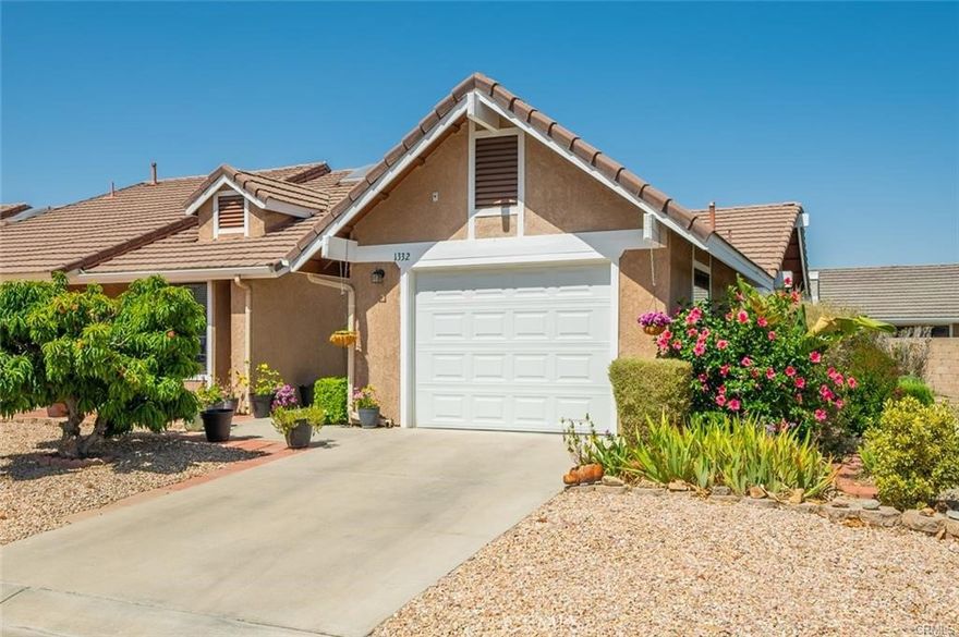 Welcome to American Village, a 55 or better community. Ideal for first time homebuyers, downsizers or investment opportunity! This end unit home is located at the back of the community and close to guest parking. American Village is a quaint community of homes attached by one common wall. No need to worry about spending hours doing yard work, as the front and back yards are water conserving and low maintenance. In the front is a fruit bearing peach tree, and out back is a lattice covered patio. This home has been well cared for and meticulously maintained inside and out by the current homeowner. Inside is an open floor plan with several windows for added natural light, ceiling fans throughout and a gas fireplace to provide ambiance to enjoy the cool winter months. The kitchen is open to the dining room and living room with counter bar seating. Direct access from the one car garage leads into the kitchen. There are two bedrooms and two bathrooms at opposite ends of the hallway. The primary bedroom has window seating with storage and a skylight in the bathroom for more natural light. Upgrades include installation of some dual pane windows and a sliding glass door, making this home more energy efficient! Additional updates include a newer stove, bathroom fixtures including faucets, lighting and mirrors. This community is very close to public transportation, major retail shops, dining, movie theater, gym and a post office. Additional entertainment not to far away includes Soboba Hotel, Casino and Golf. Low tax rate and no Mello Roos.