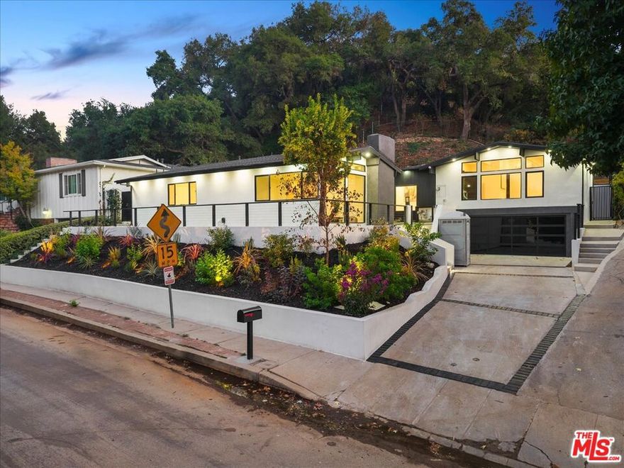 Set on a sprawling 10,114 sq ft lot just across from Royal Oaks, this newly reimagined 4 bed, 3 bath, 2,618 sq ft custom residence blends contemporary sophistication with everyday comfort and cutting-edge smart-home technology. Thoughtfully rebuilt and upgraded throughout, the home offers a fresh, turnkey living experience in one of Sherman Oaks' most desirable pockets. A statement driveway and two-car garage lead to a gated courtyard entry, creating a private and inviting first impression. Inside, soaring ceilings and walls of glass flood the space with natural light. The open-concept living area features Lutron smart lighting and a built-in Sonos audio system, enhancing the home's modern functionality. The expansive family room, anchored by a sleek modern fireplace and warm wood paneling is framed by lush landscaping, offering a seamless connection between indoor and outdoor living. The gourmet chef's kitchen is a true showpiece, showcasing a 48-inch dual fuel range, custom white oak cabinetry, and generous counter space. A five-panel folding glass door opens to a resort-like backyard complete with stone pavers, a sparkling pool, and an expansive grassy lawn perfect for entertaining or relaxing in total privacy. The well-designed floor plan includes a serene primary suite with a spa-inspired bath, two additional bedrooms sharing a full bath, and a fourth bedroom with its own ensuite. Direct garage-to-kitchen access adds everyday convenience. Fully renovated with brand new HVAC, plumbing, electrical, smooth stucco walls, and professionally designed landscaping. This residence combines the peace of a private retreat with the ease of a brand-new home all in the heart of Sherman Oaks.