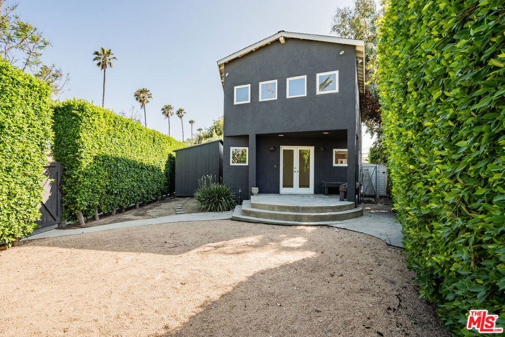 Set on a rare double lot, this character-filled property blends vintage charm with thoughtful modern updates. The home features 3,219 SF of living space on a 7,261 SF lot with 5 bedrooms and 3 bathrooms, including a guest unit with its own laundry setup. Inside, the house is cleverly divided, with a second kitchen, full bedroom, and bathroom tucked away from the primary living area. This well-crafted layout is ideal for multi-generational living, a rental opportunity, or a separate workspace. The main living area is warm and welcoming, anchored by a cozy fireplace and exposed wood beam. Sunlight pours through oversized windows, illuminating the stainless steel appliances and generous counter space in the kitchen. Upstairs, the primary suite is a peaceful escape with a double vanity, soaking tub, separate shower, and striking iridescent tile. The other bedrooms are bright and well-proportioned, with high ceilings and ample space to adapt to various needs. The backyard is private and intentionally landscaped, surrounded by mature trees and vibrant plantings, creating a tranquil setting for gathering or quiet relaxation. With its rare lot size, flexible layout, and detached guest unit, the property offers space, privacy, and the potential for future expansion or redevelopment in a prime location. Situated in the heart of Venice, this home is just moments from its iconic shops, cafes, and coastal lifestyle.