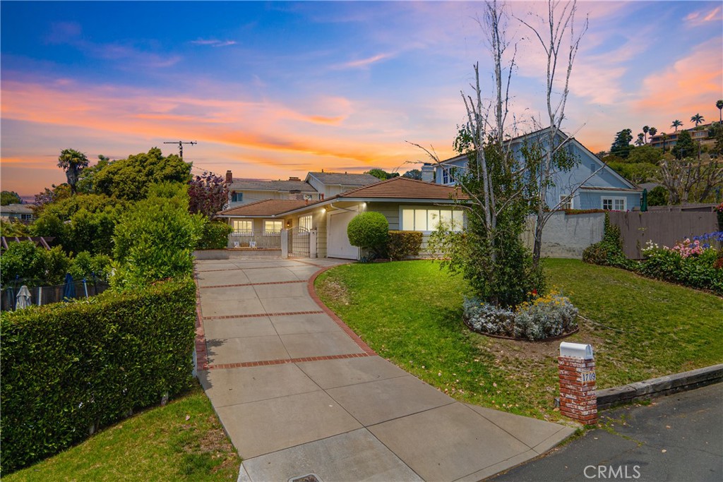 Tucked away on the elevated curve of Espinosa Circle, this inviting 3-bedroom, 2-bath home offers serenity and comfort in the vibrant and lively Lunada Bay neighborhood of Palos Verdes Estates. Set on a generous 6,781 square foot lot, this 1,583 square foot residence sits above the street, providing a peaceful retreat while remaining close to the best of the community. A welcoming front courtyard sets the stage to the entry that leads into the heart of the home, where rich wood-style flooring, recessed lighting, and an impressive fireplace add warmth and character to the living room. Both the living room and dining area open directly to the backyard, creating a seamless flow for indoor-outdoor living and filling the space with natural light. The bright and spacious kitchen features solid wood cabinetry, stainless steel appliances, timeless tile work, and recessed lighting, ready to enjoy or personalize to suit your taste. The dining area sits as the centerpoint of the home, offering easy connection to the kitchen, living room, and outdoor living spaces. The primary bedroom suite offers a restful escape with its own en-suite bathroom, while two additional bedrooms provide comfortable accommodations with thoughtful details and ample storage. From the serene front courtyard, an ideal spot for morning coffee in the cool seaside air, a quiet read, or greeting neighbors passing by, to the backyard’s grassy lawn with two patio areas, the outdoor spaces provide varied settings for relaxation, entertaining, and everyday enjoyment. Whether savoring quiet mornings, hosting weekend gatherings, or enjoying evenings under the stars, these thoughtfully designed areas extend the home's comfort beyond its interior. Situated close to excellent Palos Verdes schools, Lunada Bay Plaza with its shopping and community events, and just a short distance from the bluffs overlooking the Pacific Ocean. Palos Verdes is celebrated for its wonderful weather, peaceful community, lush landscapes, and extensive nature trails. With nearby beaches and a strong connection to nature, this location offers an exceptional lifestyle combining tranquility and beauty. This is more than just a house, it’s a wonderful place to call home in one of Palos Verdes’ most sought-after neighborhoods.