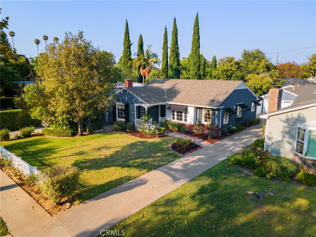If you loved watching the Gilmore Girls you might just love this home. Absolutely charming is the only way to describe it. Yes I know that word is overused in Real Estate. Take a look and we can debate it. Picket fence and roses welcome you to 2339 N Valencia, a beautiful tree lined street already. The front porch is a great place to greet neighbors walking their dogs on a shady afternoon. Custom built in 1949 by Floyd Rogers this cottage style home has shingled siding and canvas awnings. Step inside to original Red Oak floors and double hung windows which make it a candidate for historic status. The gracious Living room has 4 windows and a brick fireplace with mantle. It is very classic in it's design. There is a formal dining room just off the entry, perfect for family dinners or entertaining friends. OK the kitchen is vintage style with curved cabinets, glass upper doors, vintage glass hardware and it's French color scheme. A vintage O'Keefe & Merritt gas stove is included. The breakfast nook has 2 windows and is flooded with light. There is a laundry/mud room with additional counter space. Three bedrooms with closets and 2 baths. The main bath has been updated with new tile, cabinets and granite counter but designed with a vintage feel. The 3rd bedroom has a French door to the patio and back yard. A walk-in closet with access to a small utility basement. Behind the 2 car detached garage a bonus room was added in 1968 with a permit. What would you do with this space? The backyard has mature trees and plants and a lawn area. The roof was replaced in 2001. Park Santiago is an amazing neighborhood with a strong sense of place. A large park at it's northern border with lawn bowling, pickleball, play areas bike trail and more. Close to shopping and easy Freeway access.