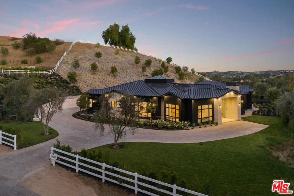 This stunning new estate in Hidden Hills is a true haven, combining unrivaled elegance, seclusion, and exceptional craftsmanship. Spanning 11,787 square feet, this exquisite residence features 6 spacious bedrooms, 7 full baths, and 3 half baths, all appointed with the finest finishes and cutting-edge smart-home technology. The expansive first floor flows seamlessly into a state-of-the-art lower level, offering versatile spaces including a home theater, gym, wine cellar, and a showroom-style garage. Designed for exceptional indoor-outdoor living, the estate boasts a resort-style pool and spa, a chic outdoor pavilion for dining and entertaining, and meticulously landscaped grounds offering complete privacy. Equestrian enthusiasts will appreciate the 2-stall barn, rounding out this one-of-a-kind property in one of Southern California's most exclusive neighborhoods.