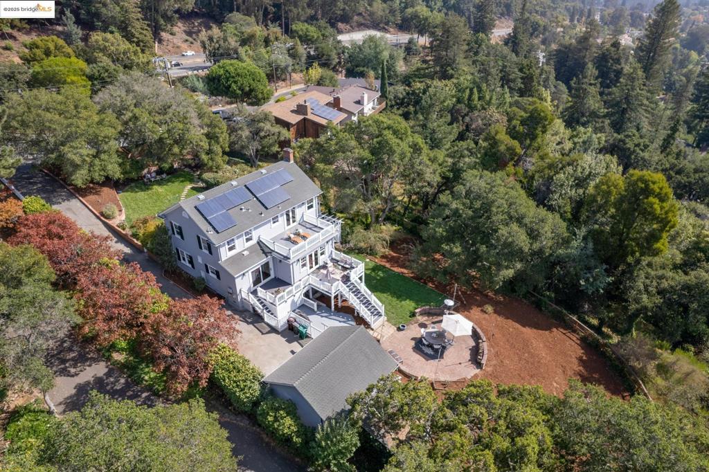 Rare opportunity to own a tranquil hillside 5 bedroom,4.5 bathroom estate with an additional 1/2+ acre separate parcel (>$200k value) Two APNs totaling 1+ acre compound! Bay views, a truly park-like setting offers a retreat mere steps from the bustle of Oakland's parks and recreation. Recent $250k+ remodel for multi-generational living, this elegant home boasts approximately 3,191 square feet. The primary suite is a true sanctuary, complete with private viewing deck, perfect for sun-bathing, yoga or quiet reflection. The home’s ideal layout includes four beds, two baths on the upper level, while the main floor features formal living, dining, a spacious kitchen with a large five ft island with built in cabinets and drawers for work station or informal dining, TV family room opening to a large outdoor deck—perfect for entertaining. The lower level offers a private au pair suite with sep entrance, 1 bed, 1 bath, kitchenette, and laundry room. Additionally, a separate 371-square-foot art studio, work out room, workspace potential for a guest house. In total, the property provides 3,434 square feet of versatile living space with room to build a second home for a family compound or rental unit. Rockridge Bart, Hwys 13, 580, 24. Joaquin Miller, Head Royce, Montclair, Redwood Heights