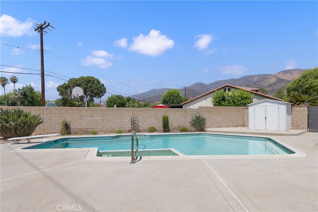 Discover your own private turnkey resort in a desirable San Bernardino neighborhood! Step inside this beautifully updated home and be captivated by the spacious living room featuring soaring vaulted ceilings, exposed beams that create an atmosphere of rustic elegance, perfectly complemented by a stunning white brick fireplace as the room's focal point. This move-in-ready gem shines throughout with fresh interior and exterior paint, new dual-pane windows, stylish plantation shutters, and gorgeous new flooring that flows seamlessly from room to room. The kitchen impresses with rich granite countertops that add both beauty and functionality to your daily living. Your private backyard oasis awaits with a gated in-ground pool and spa, two separate covered patio areas perfect for entertaining or relaxing, plus a lovely grass area for recreation. The oversized lot provides an extra-large driveway with ample space for RV or boat parking, while the entire property is enclosed by attractive brick walls ensuring complete privacy and security. Located in a sought-after neighborhood, this exceptional turnkey property offers the perfect blend of luxury, comfort, and convenience, simply move in and start living your dream lifestyle.