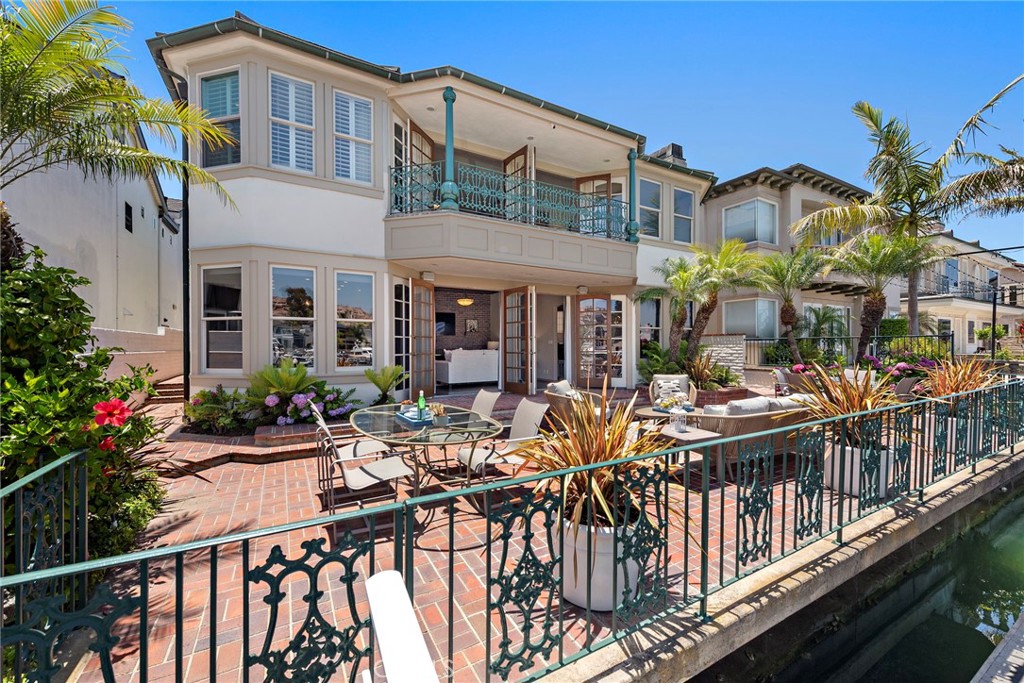 Welcome to 648 Harbor Island Drive, a waterfront sanctuary in the heart of Newport Beach’s exclusive Promontory Bay. This bespoke residence captures the romance of Old World European architecture with the ease of modern coastal living all set along 50 feet of shimmering bay frontage.
Gracefully constructed with slate roof, hand-finished brickwork, and leaded glass accents, the home offers approx. 3,898 square feet of richly detailed interiors across 4 bedrooms and 6 bathrooms. Timeless design elements include vaulted ceilings, hand-hewn wood beams, and artisan wrought ironwork creating a sense of warmth, sophistication, and craftsmanship rarely found today. At the heart of the home is The Pub, a signature entertaining space reminiscent of a traditional English club room complete with a custom wet bar, lounge seating, and French doors that open to a private patio. The formal dining room is a dramatic showpiece with cathedral ceilings and a brick accent wall stretching two stories high. The kitchen is as refined as it is functional, featuring Bosch and Viking stainless steel appliances, custom cabinetry, and generous prep space for culinary gatherings. Step outside to the expansive bayside terrace, a true extension of the home with multiple seating and dining areas designed to take full advantage of the tranquil water views. Your private dock accommodates two yachts up to approx. 55 feet, with additional space for a 3rd boat tender or Duffy making it effortless to launch into the harbor at a moment’s notice. Whether you’re entertaining by sunset, cruising the coastline, or simply relaxing in the ambiance of this timeless retreat, 648 Harbor Island Drive delivers the rare combination of European charm, waterfront presence, and Newport Beach prestige.