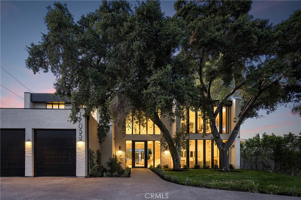Located on one of the most coveted streets south of Ventura Blvd in the prestigious Rancho Estates of Encino, this stunning modern-mid-century estate blends exceptional design with high-end craftsmanship. Its stone facade and vertical lines create a striking visual, while expansive picture windows flood the interiors with natural light. A refined selection of materials, including brushed stone, cold-rolled steel, white oak, and gunmetal finishes, creates a seamless, stylish atmosphere. The home features a chef’s kitchen, full bar, family and living rooms, office/study, cinema room, and gym, all designed for both comfort and entertainment. The luxurious primary suite includes a private balcony, a spa-inspired bath with an oversized shower, and designer walk-in closets. The outdoor space offers a pool, spa, cabana with an outdoor kitchen, fire pit, and lounging deck. An ADU provides additional flexibility, while the lush grounds, featuring olive trees and Italian cypress, offer plenty of room for play and relaxation. Ideally situated just moments from Brentwood, Bel Air, and the Westside, this home provides the ultimate in luxury living.