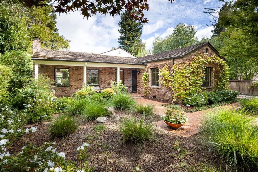 Classic Crescent Park cottage style home with updated interiors and preserved period details. Exterior brick cladding accented with Boston ivy, freshly painted interiors, gleaming hardwood floors, and original metal-framed casement windows. The spacious living room, wrapped in windows and a glass-paned door to the rear yard, features a fluted-mantel fireplace as the focal point. The formal dining room is highlighted by a modern five-light globe chandelier. The bright kitchen has space for a breakfast table and features newly painted taupe cabinetry with white tile countertops and full-height backsplashes, plus all-white appliances including a gas range, dishwasher, and refrigerator. 3 bedrooms and 2 updated dual-entry baths include one with tub and one with frameless-glass shower. The private rear yard with living wall provides raised garden beds, Japanese maples, and expansive brick patios that wrap around to one side of the home. Separate laundry room with washer/dryer, detached one-car garage, abundant off-street parking, and security alarm. Exceptional location just 2 blocks from Eleanor Pardee Park, 1 mile to University Avenue shops and restaurants, and access to acclaimed Palo Alto schools.