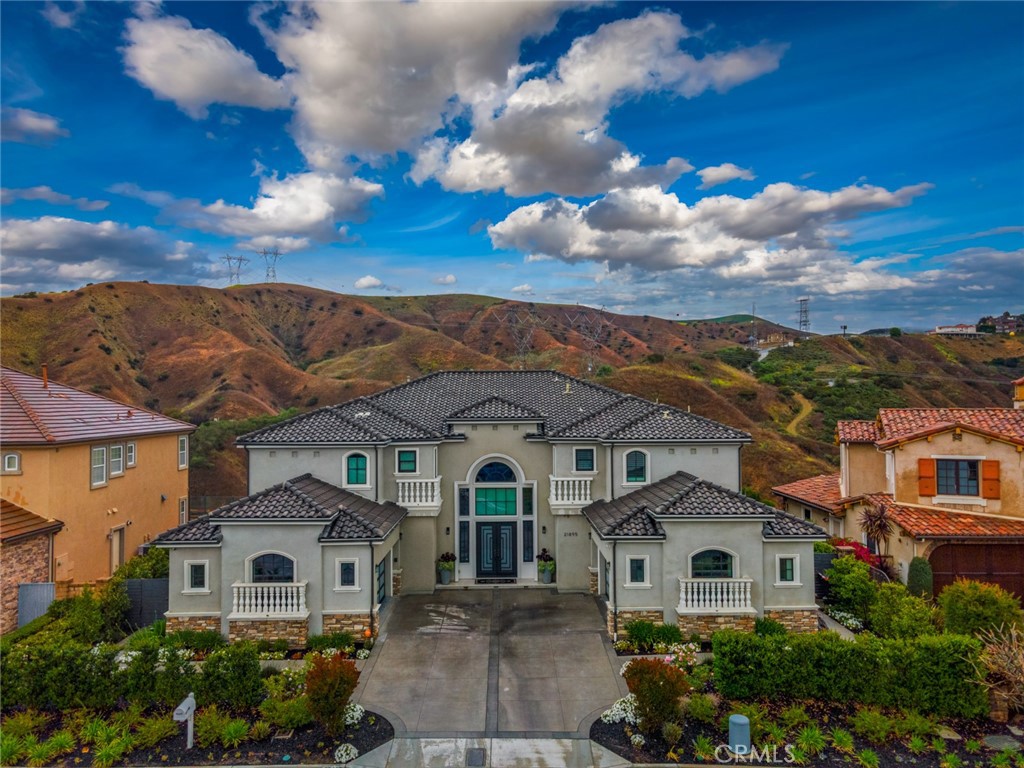 Nestled within one of Yorba Linda’s most prestigious and secluded enclaves, this exquisite custom estate masterfully blends luxurious living with everyday comfort. Re-Built in 2017 and thoughtfully elevated with almost $700,000 in enhancements since, every detail has been curated to deliver a truly unmatched indoor-outdoor lifestyle experience.
Step through the impressive new custom front door into a world of elegance, where a dual staircase, gorgeous marble and wood flooring, and coffered ceilings immediately capture your attention. The open-concept living spaces flow seamlessly, centered around a spectacular great room featuring a state-of-the-art projector and a chef’s kitchen featuring gleaming Quartz countertops, double oversized islands, a built-in Thermador refrigerator, top-tier stainless steel appliances, and a secondary Wok kitchen for effortless entertaining.
A full wall of accordion glass doors invites you to the ultimate private backyard sanctuary — complete with a resort-style pool and spa, sunken firepit lounge, built-in outdoor kitchen with BBQ and beverage centers, putting green, and multiple covered seating areas for year-round al fresco living. This is true Southern California luxury at its finest.
The first floor also offers a private guest suite and a custom wine room, perfect for showcasing your collection and entertaining guests in an intimate, sophisticated setting. Upstairs, you'll find three secondary bedrooms, the newly built laundry room, and an inviting loft. The primary suite is its own oasis, featuring a private balcony with breathtaking canyon views, an oversized walk-in closet, and a spa-caliber primary bath complete with steam shower, separate sauna, dual vanities, and luxurious soaking tub. Additional upgrades include custom-built garage cabinetry, upgraded garage doors, designer window treatments throughout, and a full Sonos sound system seamlessly integrating both indoors and outdoors.
Located within minutes of Yorba Linda’s premier attractions — including the award-winning Yorba Linda High School, the Black Gold Golf Club, and the upscale dining and shopping of Yorba Linda Town Center — this home perfectly balances privacy and convenience. Miles of equestrian trails, parks, and preserved open space are just moments away, allowing you to enjoy the natural beauty that defines this coveted community.
21895 Heatheridge is more than a home — it’s a private luxury retreat where every day feels like a vacation.