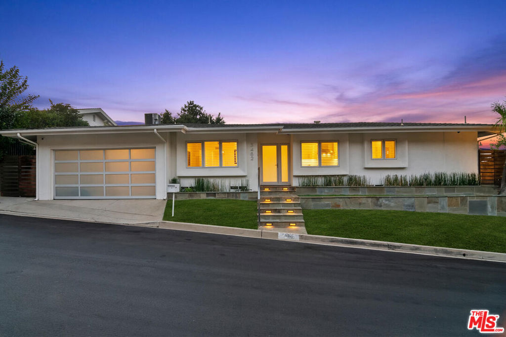 Chic, modern single-story view home located in a prime Sherman Oaks neighborhood just north of Mulholland Drive. Tastefully remodeled, this light and airy open floor plan is ideal for everyday living and entertaining. Wide-plank Camarilla Oak hardwood floors and Fleetwood glass doors throughout. Formal dining room and remodeled kitchen with stainless steel appliances, built-in wine cooler, and breakfast area. Walls of glass open to beautiful city light and mountain views. The primary suite offers a sitting area, scenic views, a walk-in closet, and an en suite bathroom. Outdoors, enjoy a natural stone patio, deck with firepit, lawn, and garden areas. Additional highlights include an indoor laundry room, extra storage and closet space, and a large two-car attached garage with direct entry to the home. Convenient access to Beverly Hills, Century City, and the Westside. Located in the Roscomare Road School District.