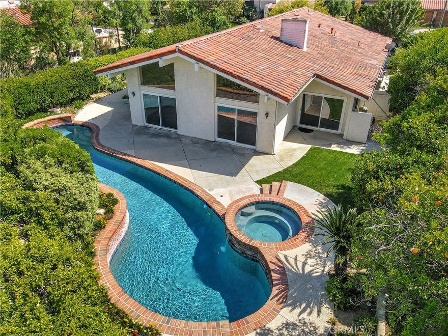 Welcome to this exquisite 3-bedroom, 3-bathroom single-story sanctuary nestled in the Calabasas Park neighborhood of Calabasas! Tucked away on a serene cul-de-sac, this home radiates refined sophistication and warmth. A grand entryway invites you into a luminous, open-concept living space with soaring vaulted ceilings, gleaming stone floors, and a cozy fireplace. The chef’s kitchen is a culinary masterpiece, featuring a spacious center island, custom-crafted cabinetry, and built-in shelving for media and storage. The primary suite offers a private retreat with a fireplace, expansive walk-in closet, additional wardrobe space, and an ensuite bathroom with dual vanities and tiled shower. On the opposite wing, two spacious bedrooms  share a sleek bathroom with a modern vanity. The front yard, enveloped by lush greenery and towering trees, ensures tranquil privacy, while the backyard is a stunning oasis with a sparkling pool, cascading spa, verdant lawn, and generous space for entertaining. Additional upgrades include a newer roof, newer water heater, and dual pane windows throughout. Just moments from the exclusive Calabasas Lake, vibrant Old Town Farmer’s Market, and The Commons for premier shopping and dining. Discover this Calabasas gem today!