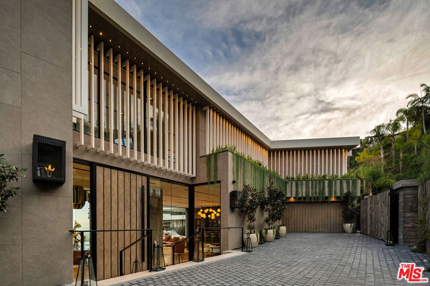 Seller accepts crypto! Conceived and executed with the modern mogul's ambition top of mind, this newly constructed palace offers sweeping, uninterrupted views of the canyon and Los Angeles skyline, spanning 500 feet of frontage in a coveted Bird Streets enclave. Enter beneath a bespoke chandelier and cascading fountains into a 13-foot living room anchored by layered stone fireplaces. The Arclinea kitchen opens to a European-inspired wine room illuminated by a sculptural pendant. Floor-to-ceiling glass panels dissolve the line between indoors and outdoors, revealing expansive terraces with an 18-foot sunken fire pit, a 100-foot infinity pool, a 30-person spa, and a sand volleyball court, each set against sweeping vistas. The primary suite serves as a private retreat, featuring a reading vestibule, a 1,500-square-foot balcony with Jacuzzi and fire features, dual dressing rooms, and a travertine-clad bath with twin soaking tubs and panoramic views. Tailored for both comfort and spectacle, the home also includes a command center-style office, a full screening room, a gym, hookah and meditation lounges, a panic room, a shoeshine station, and more. Designed with intent, the residence is as functional as it is striking. Revel in the pinnacle of modern elegance, all while being enveloped by some of Southern California's most breathtaking views.