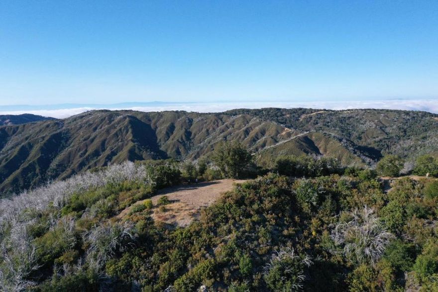 This rare 102 acre parcel of Big Sur wild land contains one of highest  points on the Big Sur coast in the northern Santa Lucia Mountain Range:  Twin Peaks at 3570 ft.       The property has direct access  to the Ventana Wilderness, the Los Padres National Forest and the Palo Corona Biological Preserve.  There is easy access from a County Road off Hwy 1 onto a private gated well maintained unpaved road. It's a little over an hour from Carmel and the Monterey airport to seclusion, endless sunshine and the brilliant night sky.  High above the fog and the redwood canyons flowing down to the wide blue Pacific there are views southwest across the forested mountain wilderness to Pico Blanco and the Big Sur River watershed. North and east are views all the way across Monterey Bay to Santa Cruz and in the distance Carmel Valley. Design and build your own kingdom or bring your sprinter van and glamp siurrounded by wildlife in an endless forest.