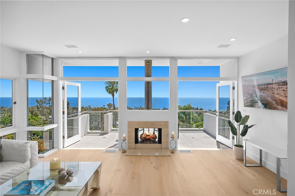 Retreat to a private world of luxury and breathtaking ocean and whitewater views at this spectacular custom home in Laguna Beach. Welcome to 1061 Skyline Drive, an artfully reimagined residence tucked into the desirable Lower Mystic Hills enclave. Set against a stunning backdrop of unobstructed, 180-degree vistas stretching across the Pacific Ocean and Catalina Island, this exceptional 4-bedroom, 4-bathroom home offers over 3,300 square feet of elevated coastal living. Thoughtfully upgraded with timeless elegance, the home features a soft, neutral palette that compliments wide-plank hardwood flooring, vaulted ceilings, and expansive walls of glass that flood the interiors with natural light and perfectly frame the dramatic ocean views. The designer kitchen is both refined and functional, showcasing porcelain countertops, custom cabinetry, and premium Sub-Zero and Thermador appliances—ideal for both everyday living and stylish entertaining. Main living areas extend to ocean-facing view decks, where year-round sunsets and gentle coastal breezes set the tone for effortless indoor-outdoor living. The primary suite serves as a private sanctuary, complete with a fireplace, walk-in closets, a spa-inspired bath, and a secluded terrace with sweeping views. On the lower levels, three additional bedrooms accompany a secondary living area—perfectly suited as a home theater with a retractable cinema screen and high-resolution projector. These spaces open directly to a large entertaining deck and an oversized, landscaped backyard—offering privacy, versatility, and a beautiful setting for gatherings or quiet evenings under the stars. The home’s enviable location provides easy access to world-renowned beaches, scenic parks, and the acclaimed restaurants, cafés, galleries, and shops that define Laguna Beach living. Montage Resort and The Ranch at Laguna Beach are just minutes away. Award-winning public schools serve the community, and the vibrant village is only moments from your door. Imagine, for a moment, sharing a home of this caliber with the people you love. Now, make it yours.